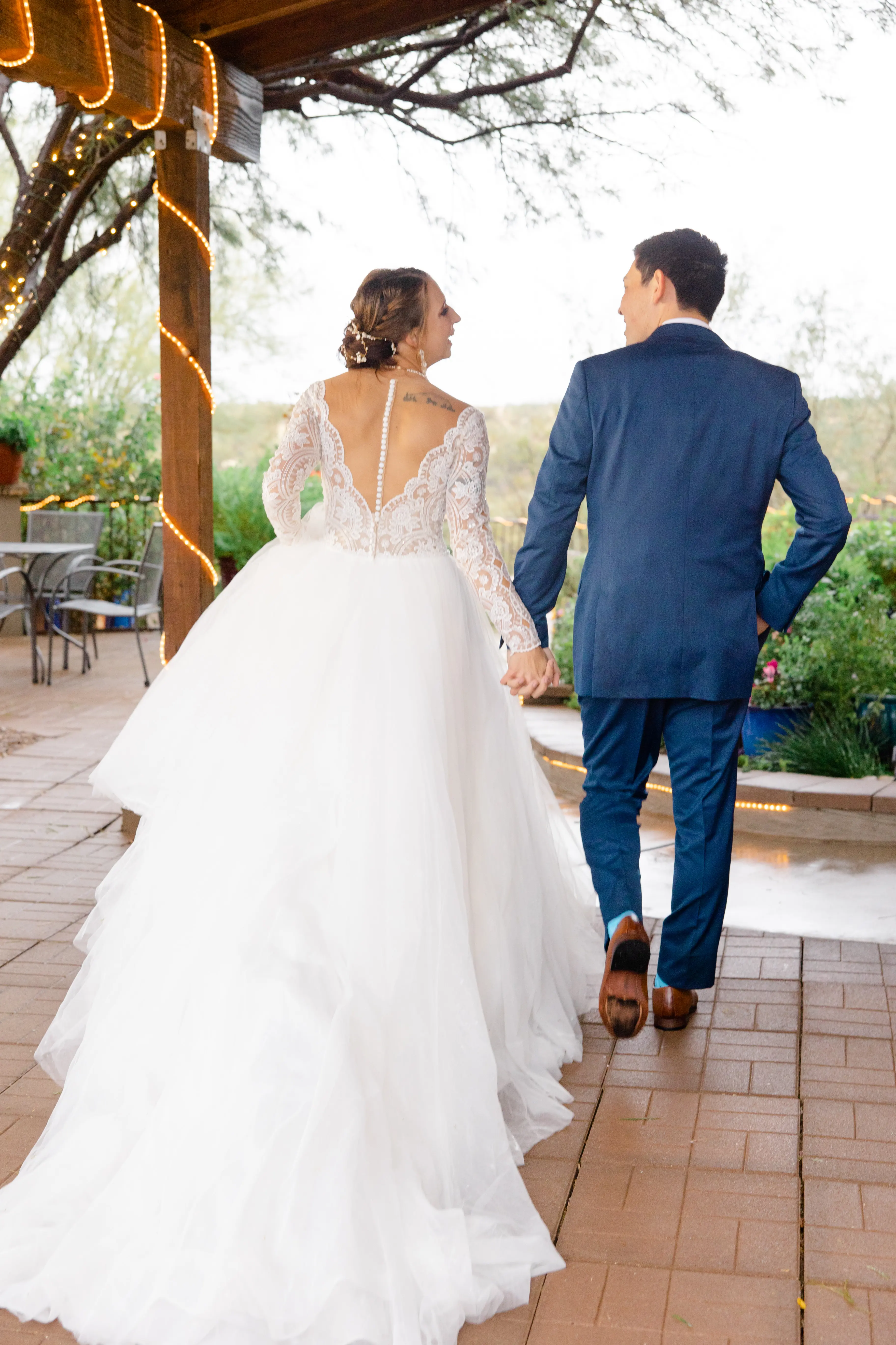 Groom Holding Hands with Bride in Romantic Long Sleeve Ball Gown Wedding Dress with Lace Motifs on Nude Bodice and Tulle Skirt Called Mallory Dawn by Maggie Sottero