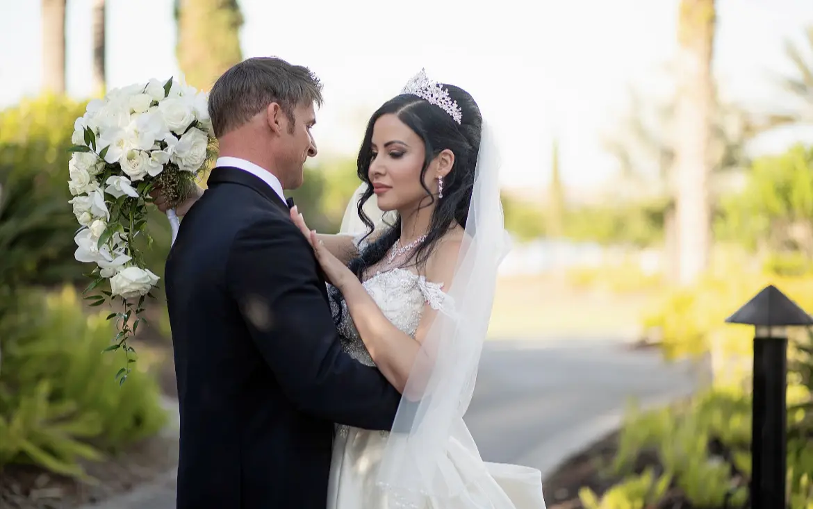 Bride wearing elegant satin ballgown called Kimora by Sottero and Midgley with groom