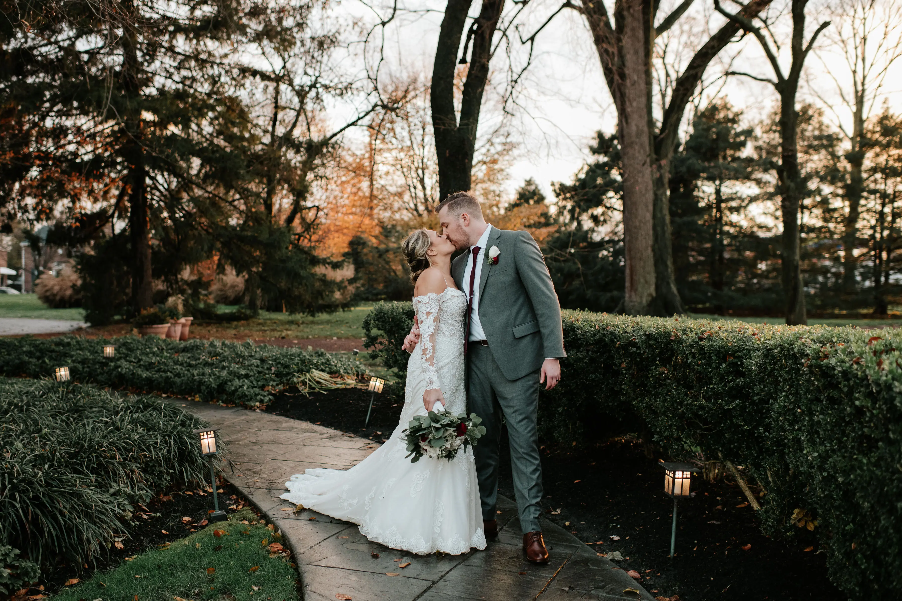 Groom Kisses Bride in Sparkly Lace Fit-and-Flare Bridal Dress with Off-the-Shoulder Sleeves Called Fiona by Maggie Sottero