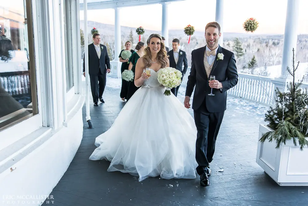 Bride with groom wearing strapless ballgown tulle wedding dress with sweetheart neckline outdoors.
