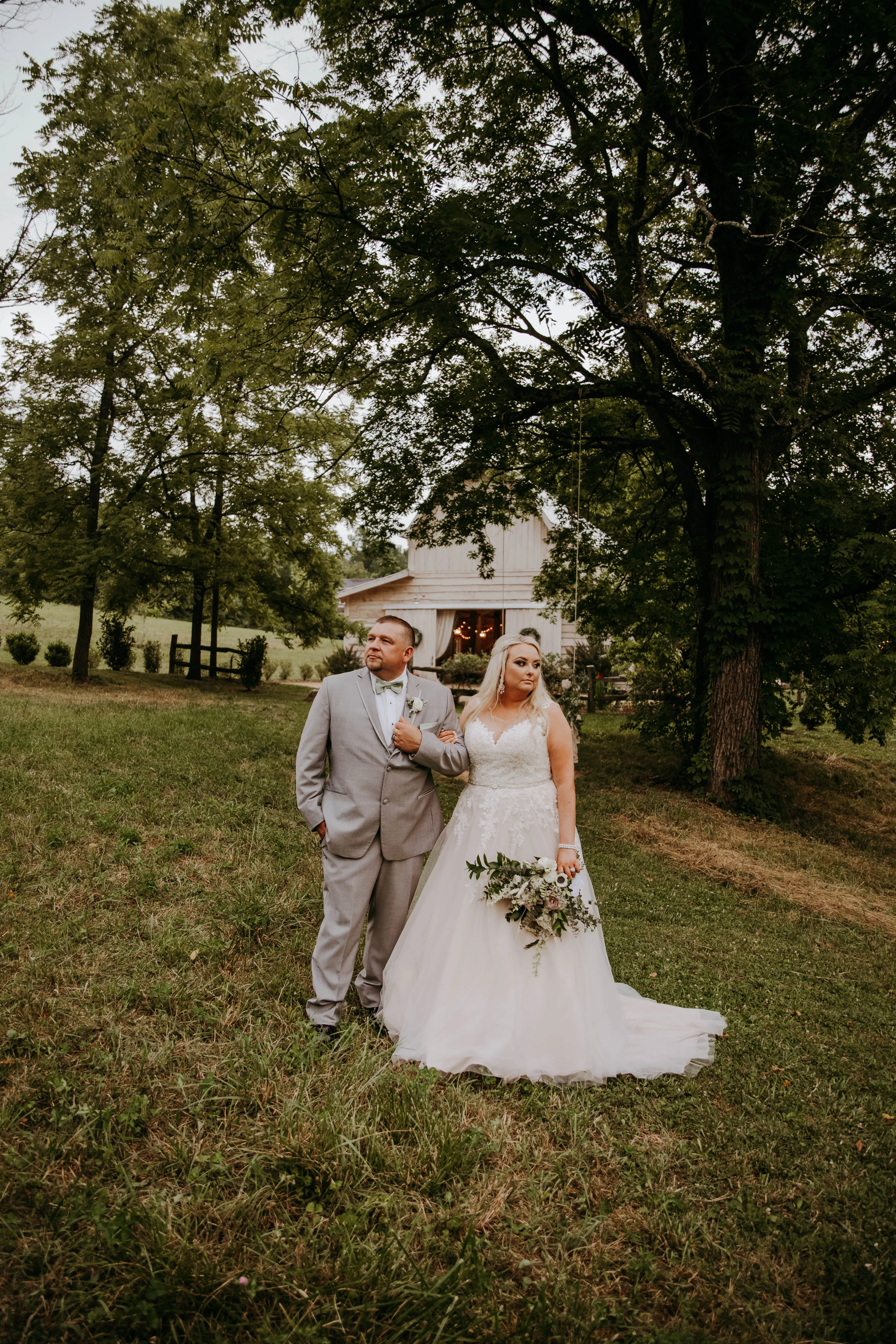 Groom and Bride at an Outdoor Wedding Wearing Lace Ballgown Wedding Dress Called Olivia by Rebecca Ingram