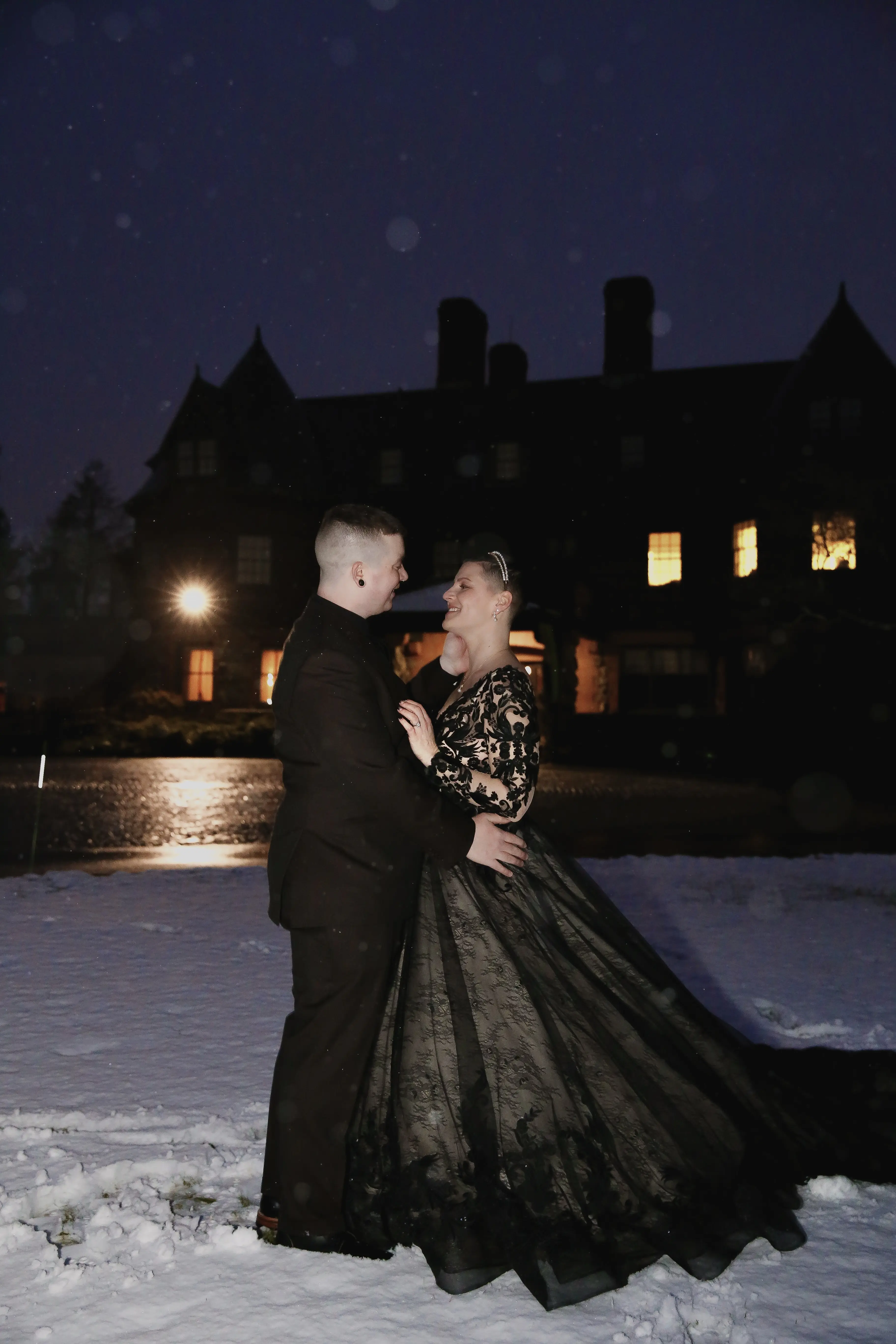 Groom Kissing Bride In Black Wedding Dress Named Zander By Sottero and Midgley In The Snow