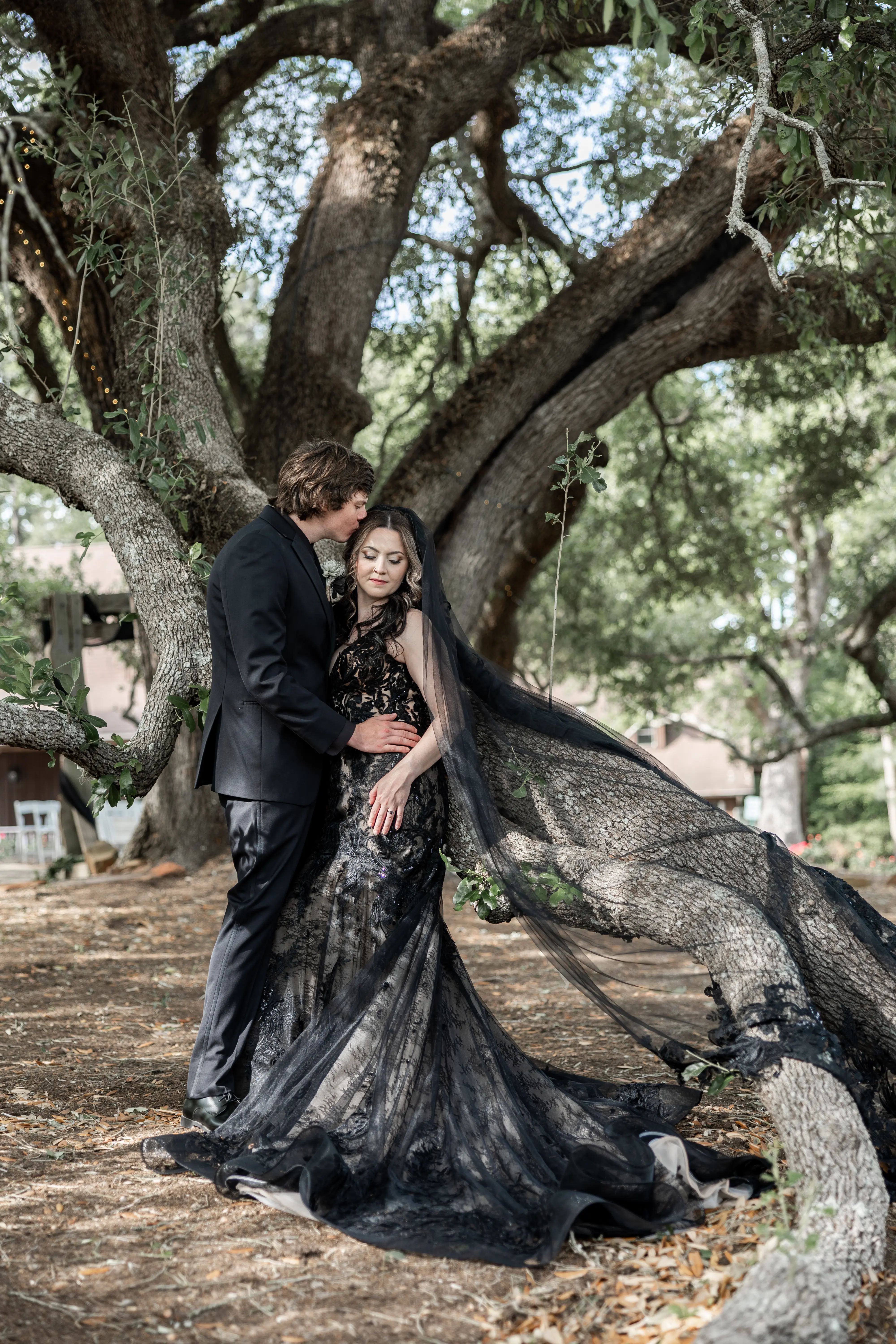 Bride wearing Zander Lane by Sottero and Midgley with her husband in front of a tree