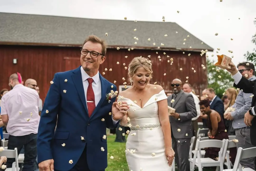 Bride wearing Josie by Rebecca Ingram with her husband getting hit with popcorn