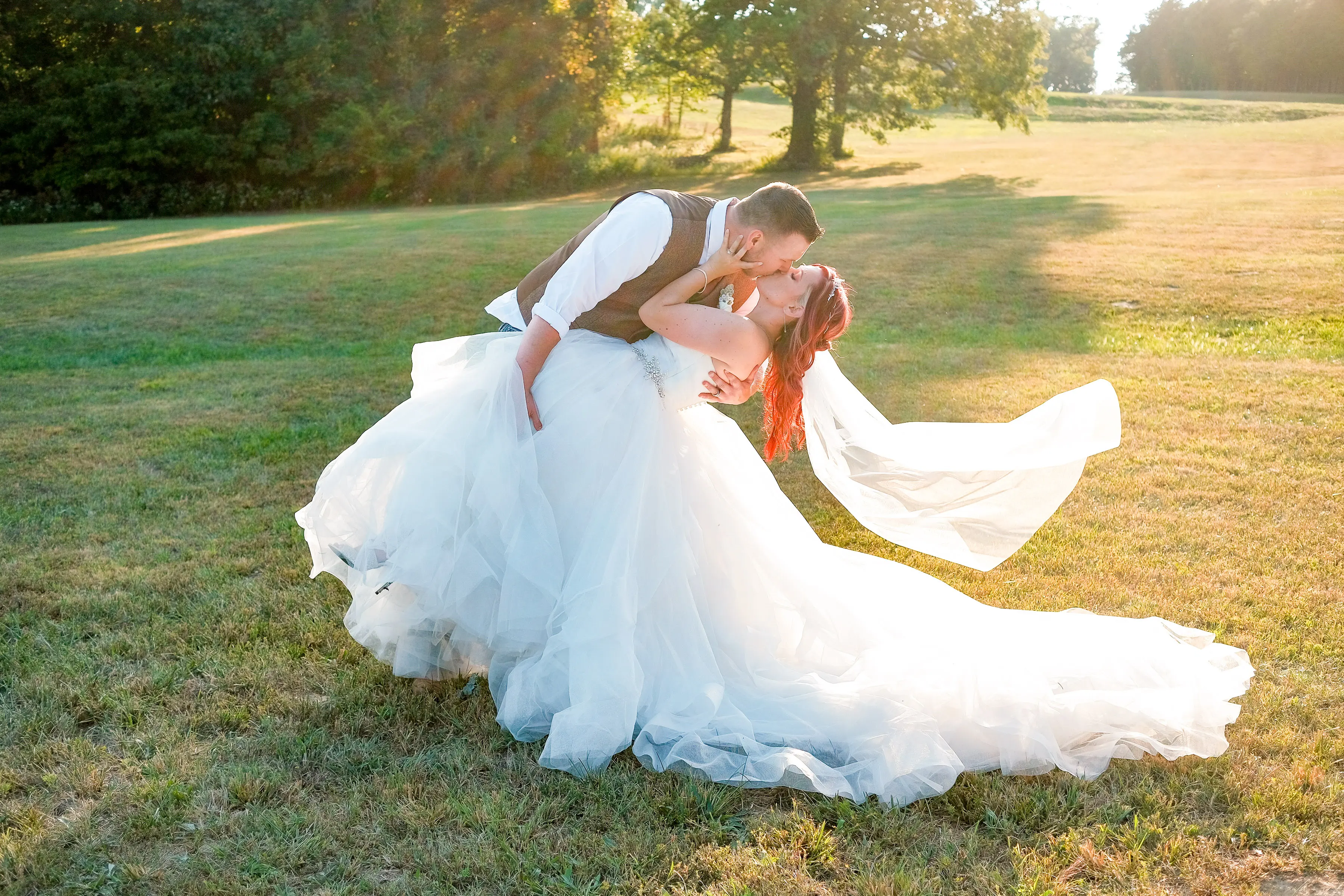 Bride Wearing Sparkly Princess Ballgown Wedding Dress Called Yasmin By Maggie Sottero Kissing Groom In A Field