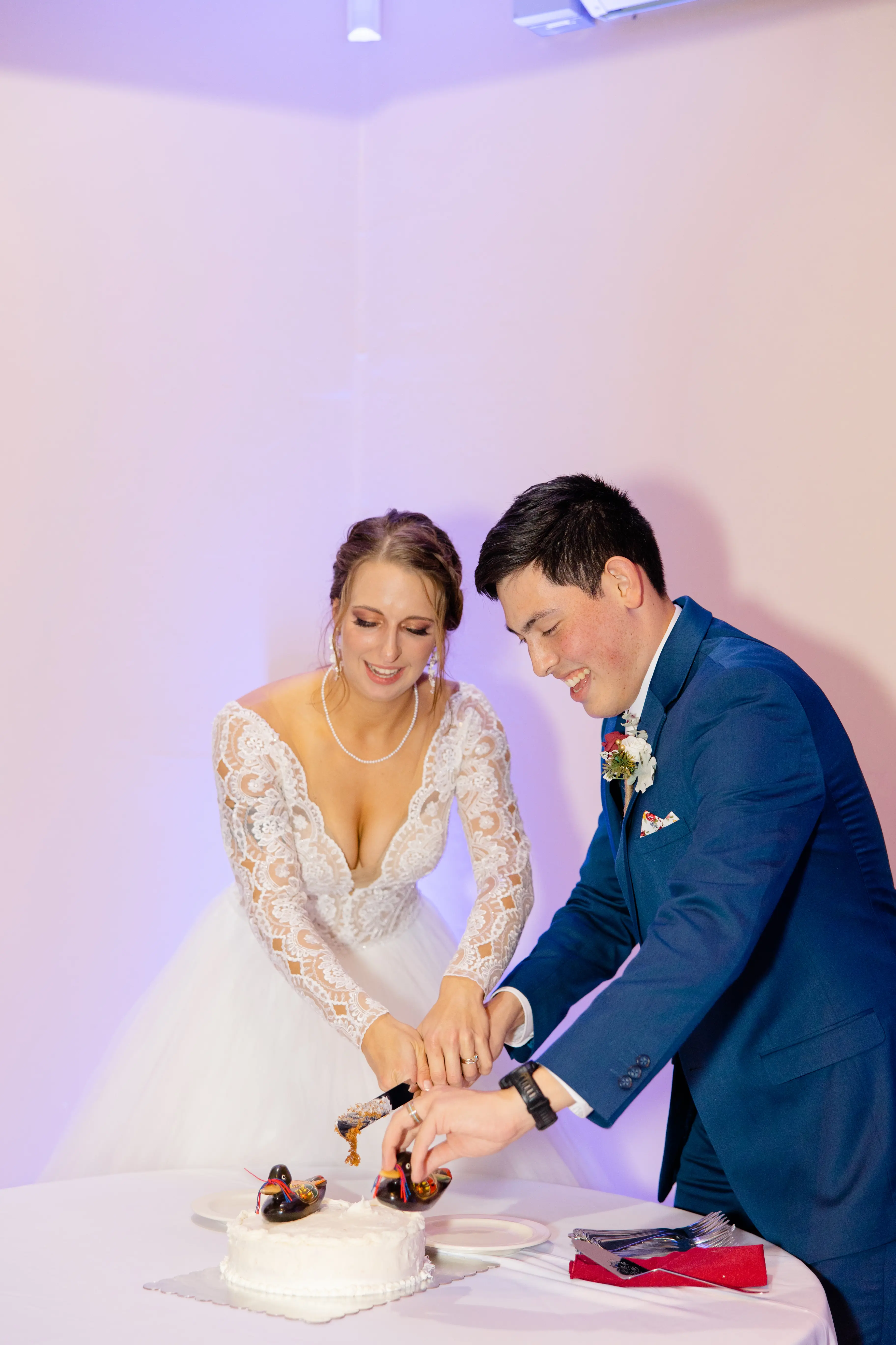 Groom Cuts Cake with Bride in Romantic Long Sleeve Ball Gown Wedding Dress with Lace Motifs on Nude Bodice and Tulle Skirt Called Mallory Dawn by Maggie Sottero