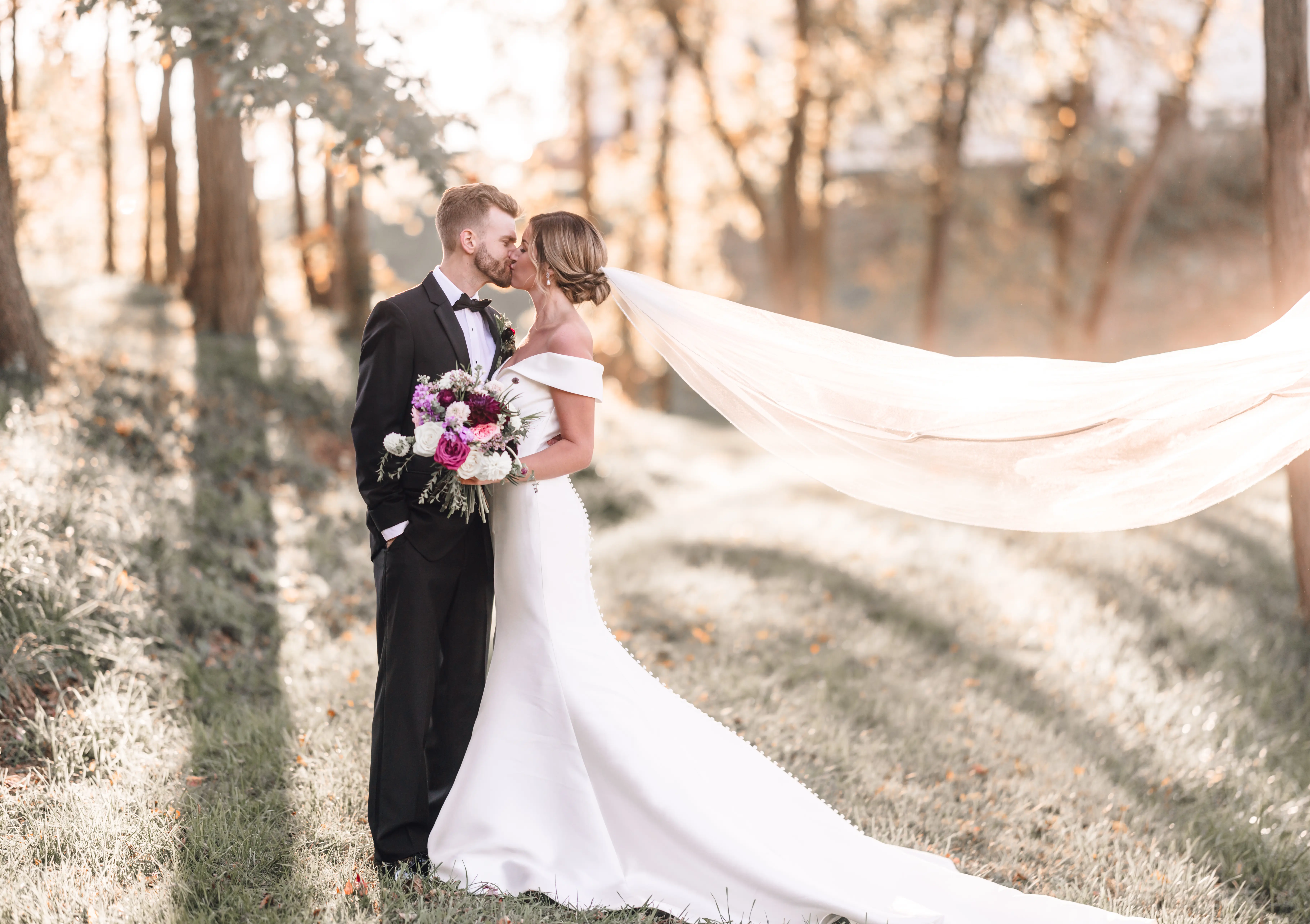 Groom Kissing Bride In Off The Shoulder Fit And Flare Wedding Dress Named Josie By Rebecca Ingram With Long Veil