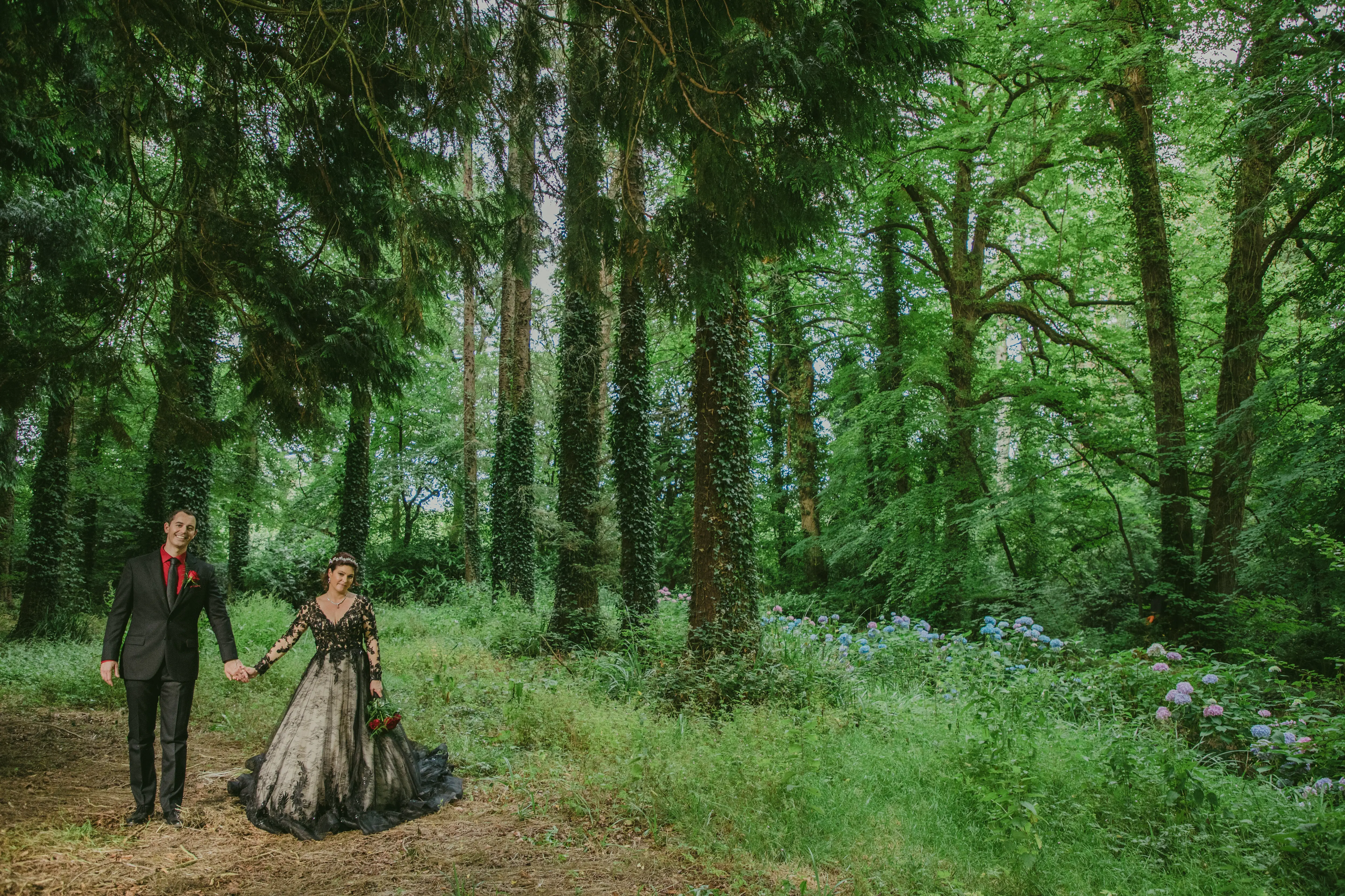 Bride wearing Zander wedding dress by Sottero and Midgley holding hands with husband