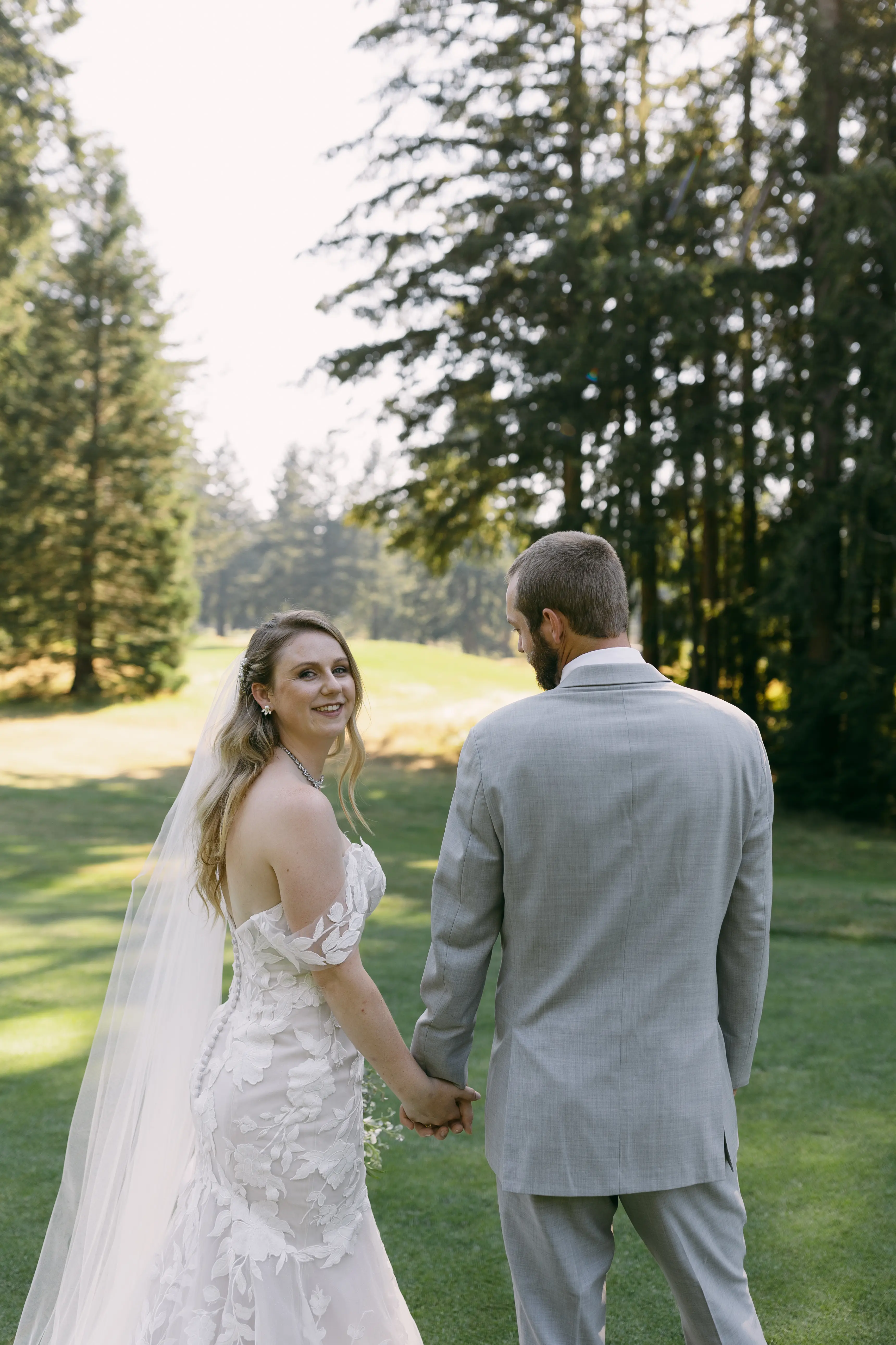 Bride in Strapless Mermaid Wedding Dress Named Hattie By Rebecca Ingram Bride and Groom Holding Hands In Woods