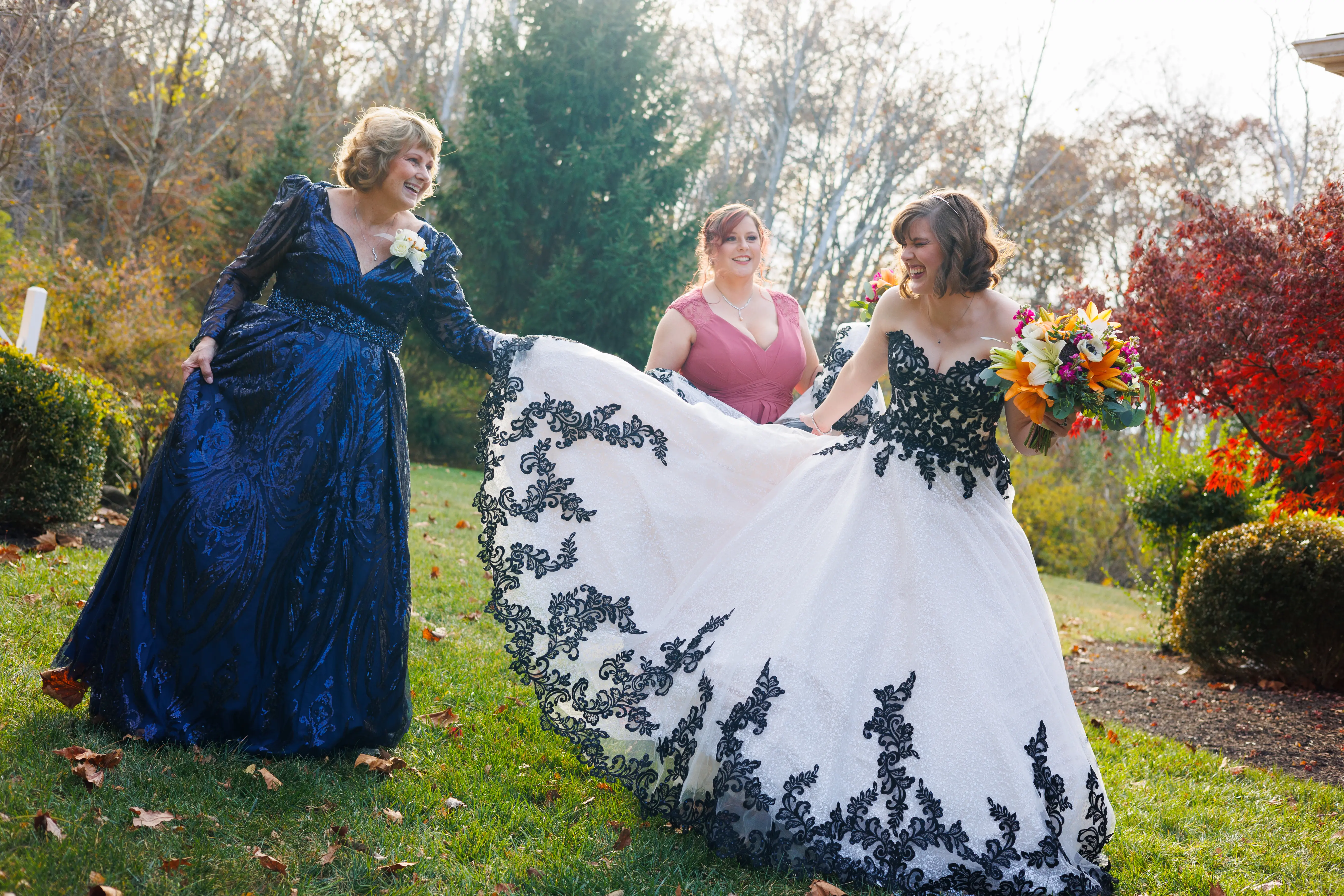 Bride And Family Showing Off Wedding Dress. Bride Wearing Black And White Lace Strapless Ball Gown Called Tristyn By Maggie Sottero