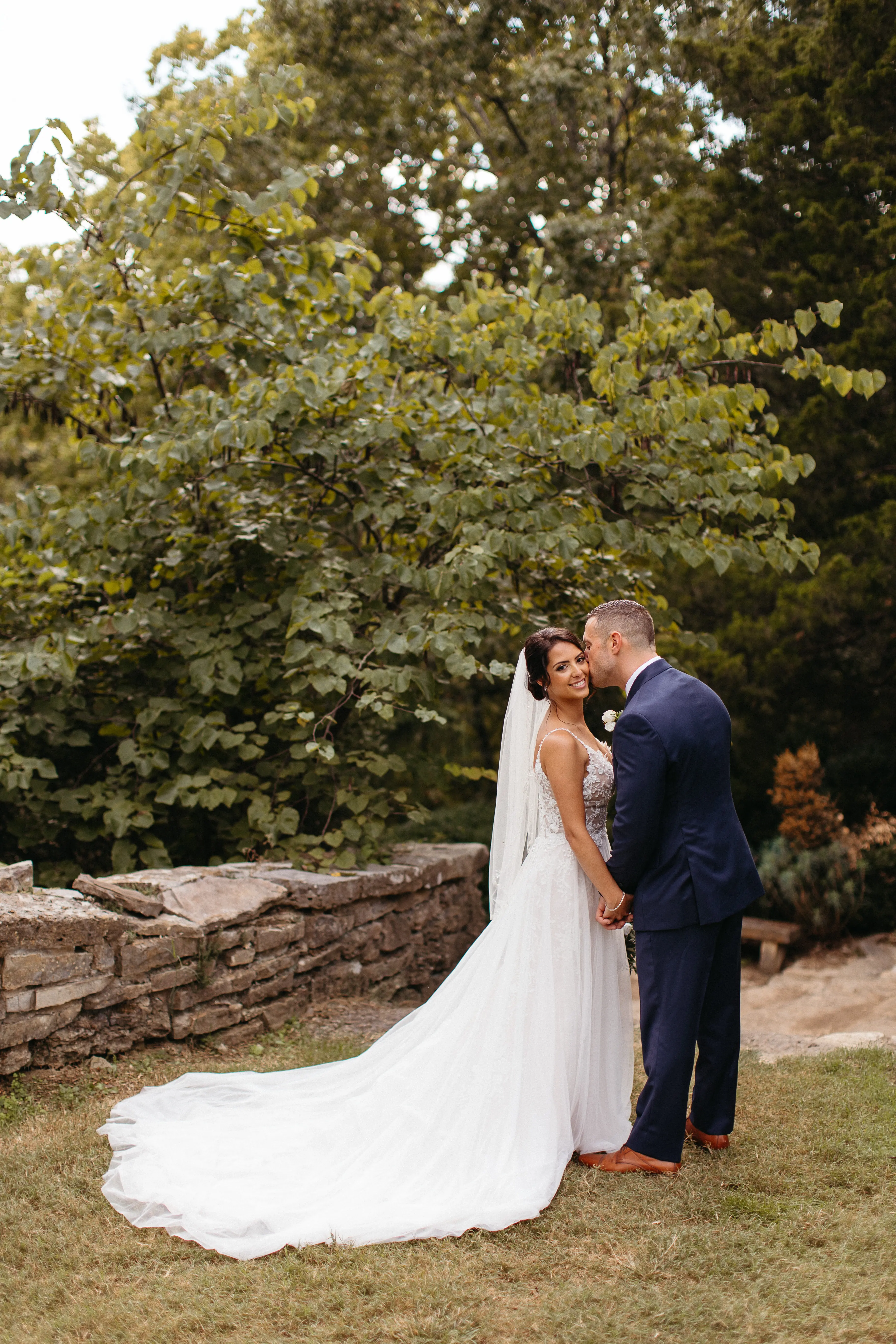 Groom kissing his bride on the cheek.