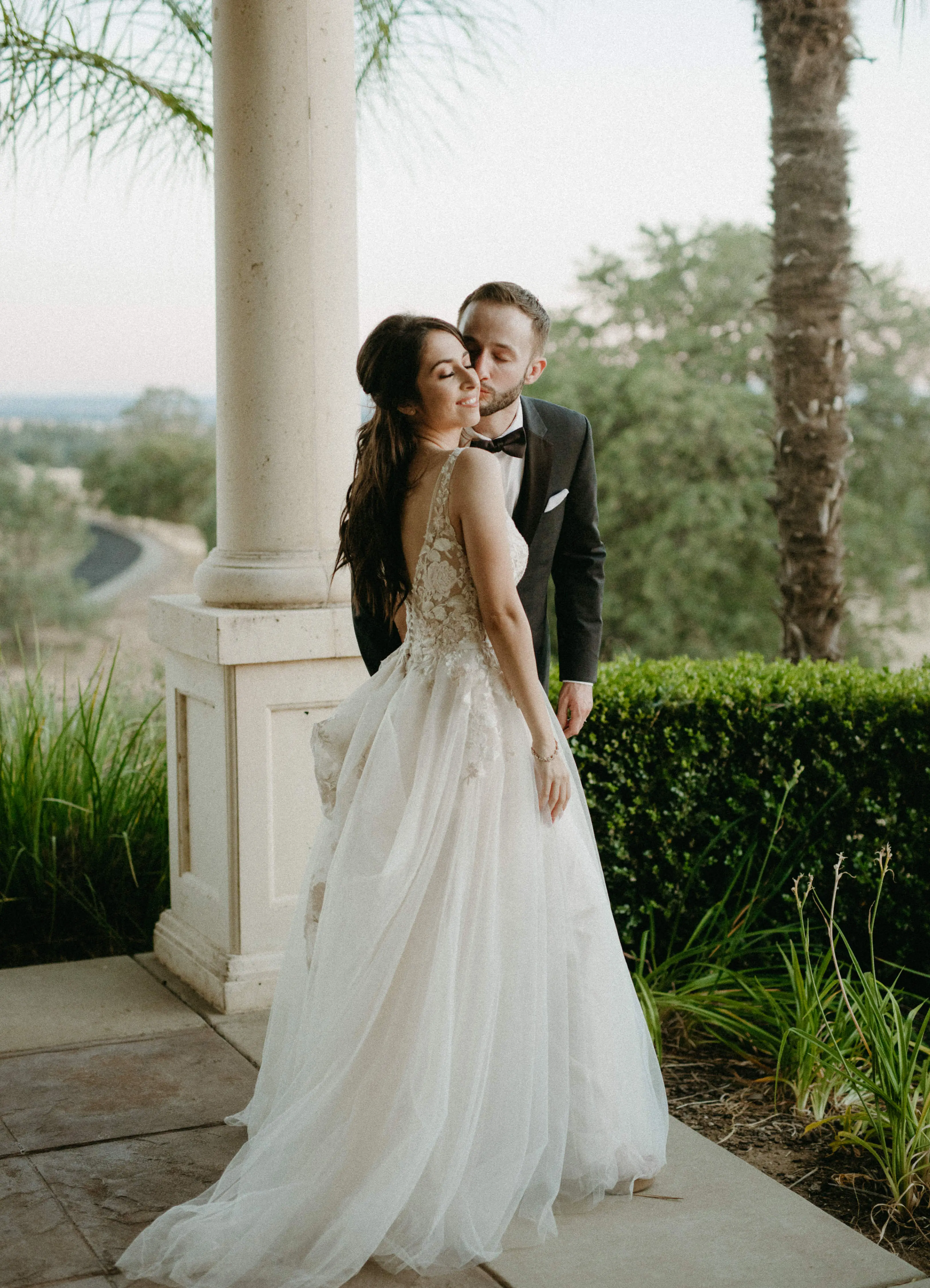 Groom Kissing Bride in Magical A-Line Wedding Dress with Textured Illusion Motifs Called Minerva by Rebecca Ingram