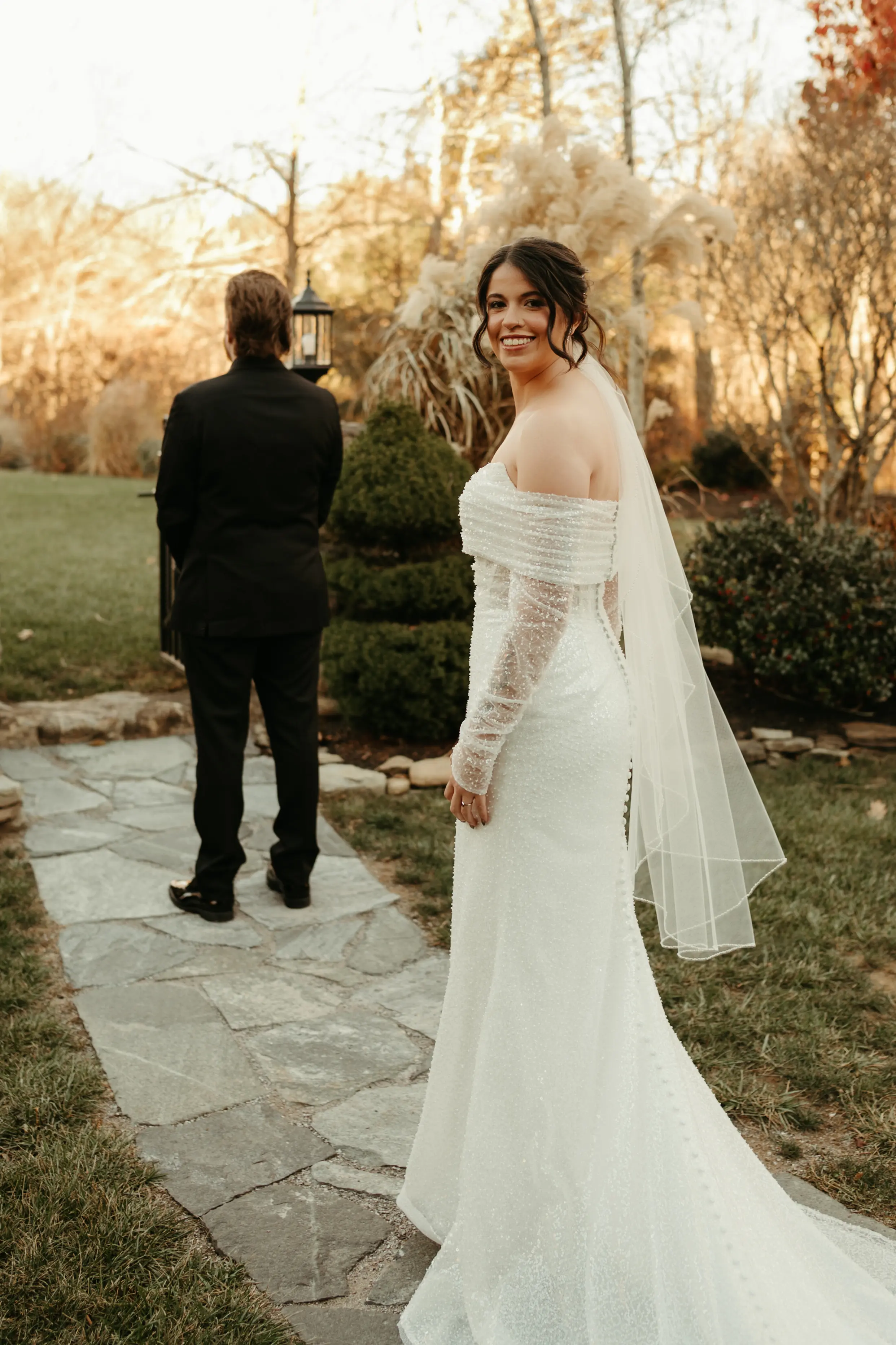 Bride Wearing Pearl Sparkly Wedding Dress Called Drew By Maggie Sottero Standing Behind Groom For First Look