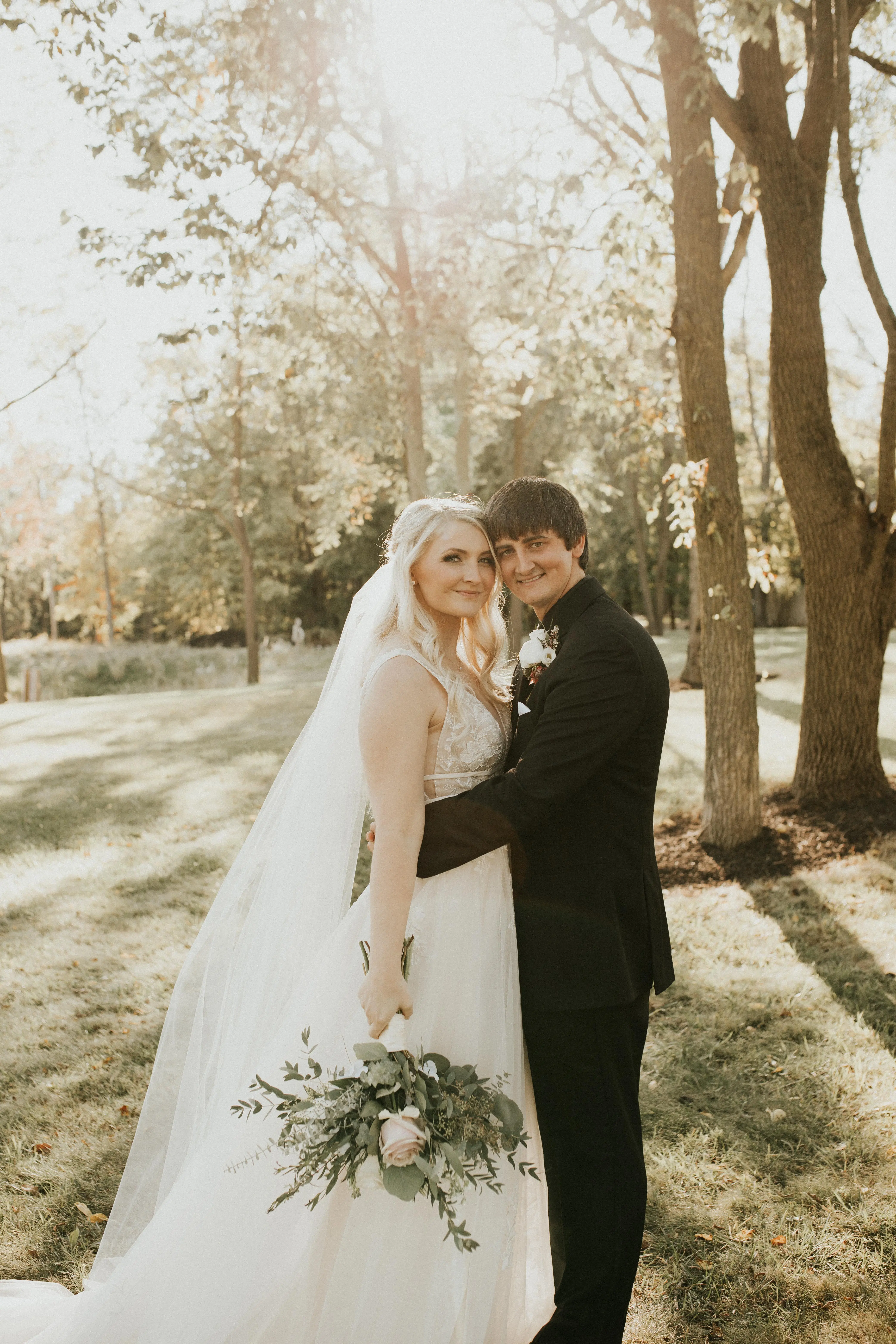 Groom Hugging Bride Wearing Bridal Dress Called Raelynn by Rebecca Ingram
