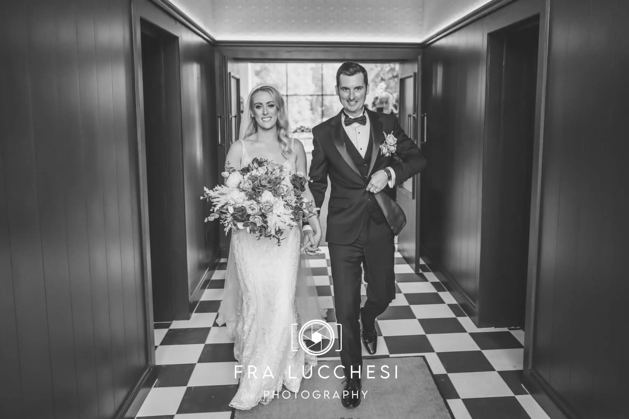 Bride wearing Bailey wedding dress by Sottero and Midgley holding hands with her husband