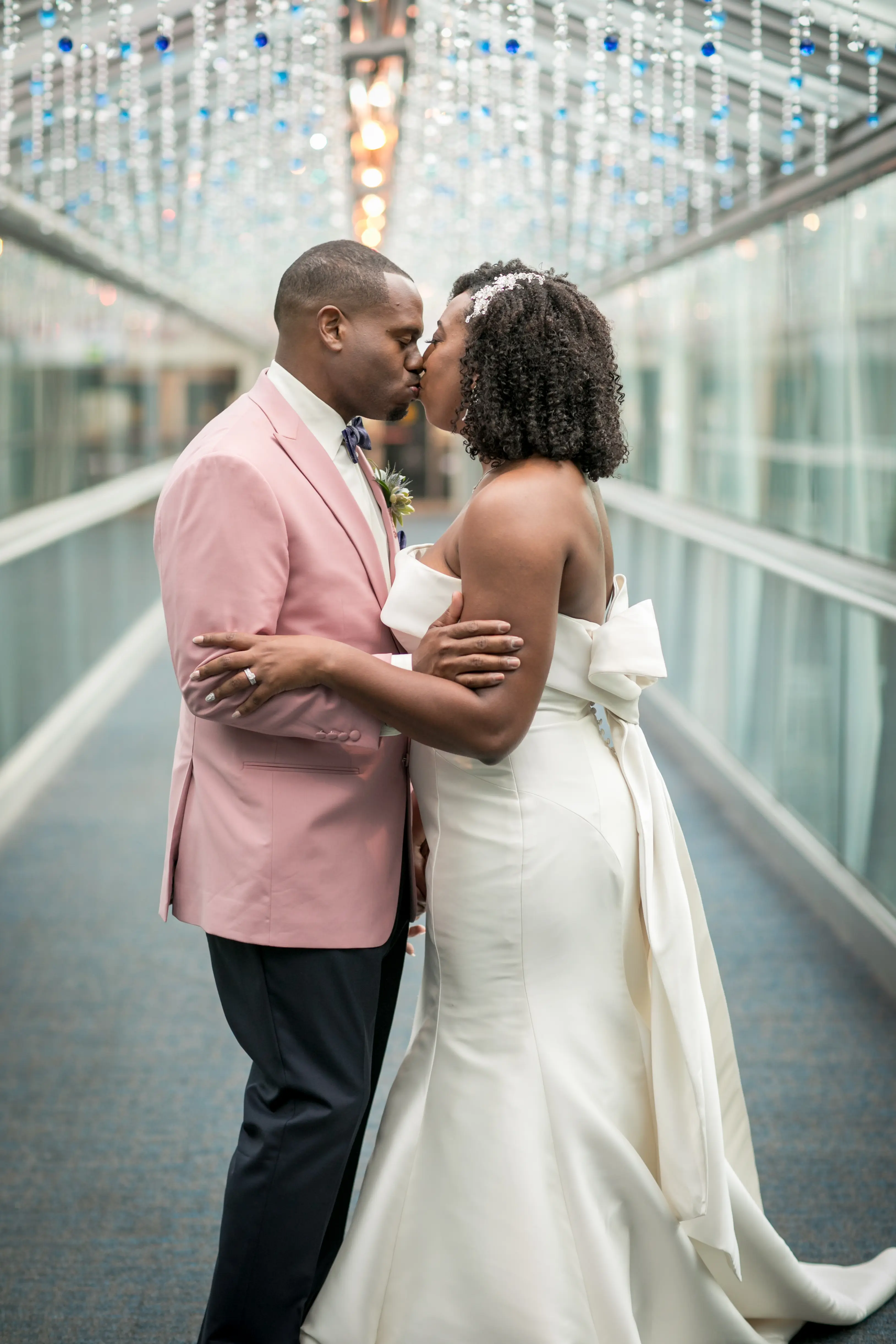 Groom Kissing Bride In Strapless Fit And Flare Wedding Dress With Bow Named Mitchell By Maggie Sottero