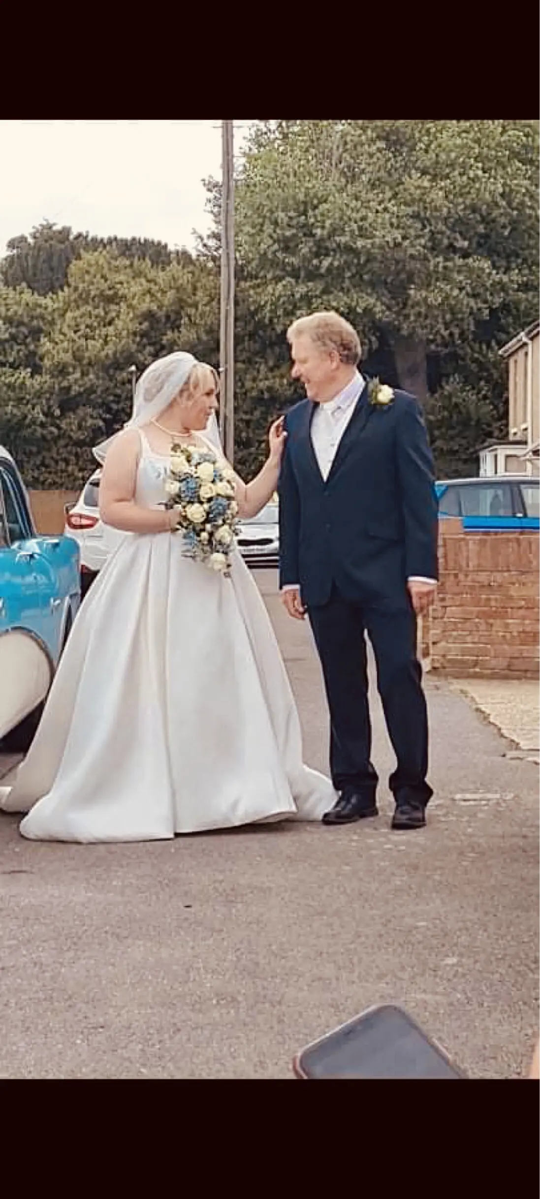 Bride talking to her Father with hand on his shoulder.