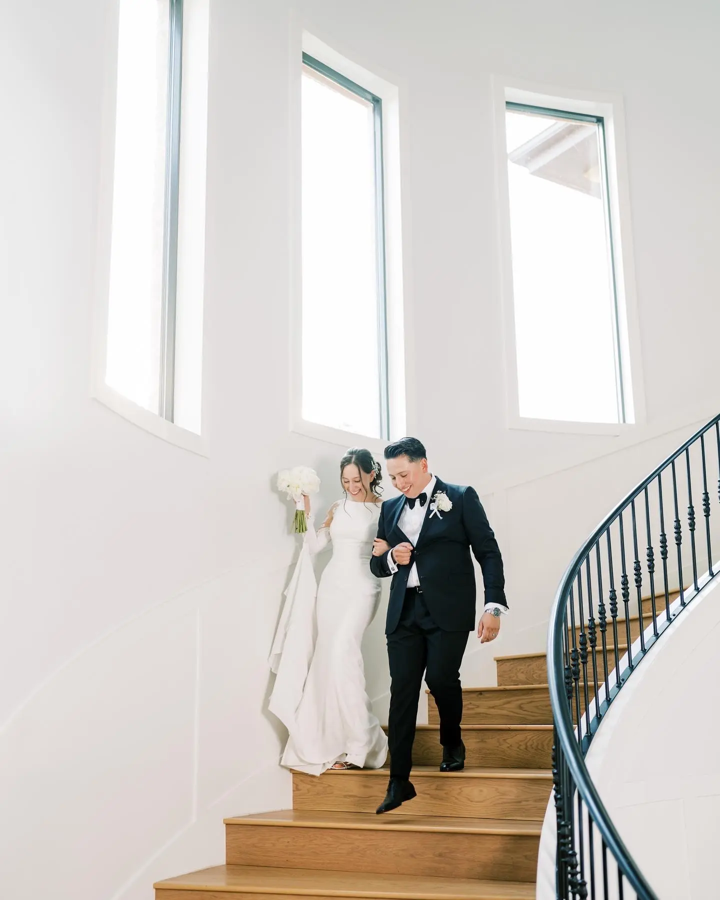 Bride Wearing Simple Long Sleeve Wedding Dress Called Bethany Walking Down The Stairs With Groom