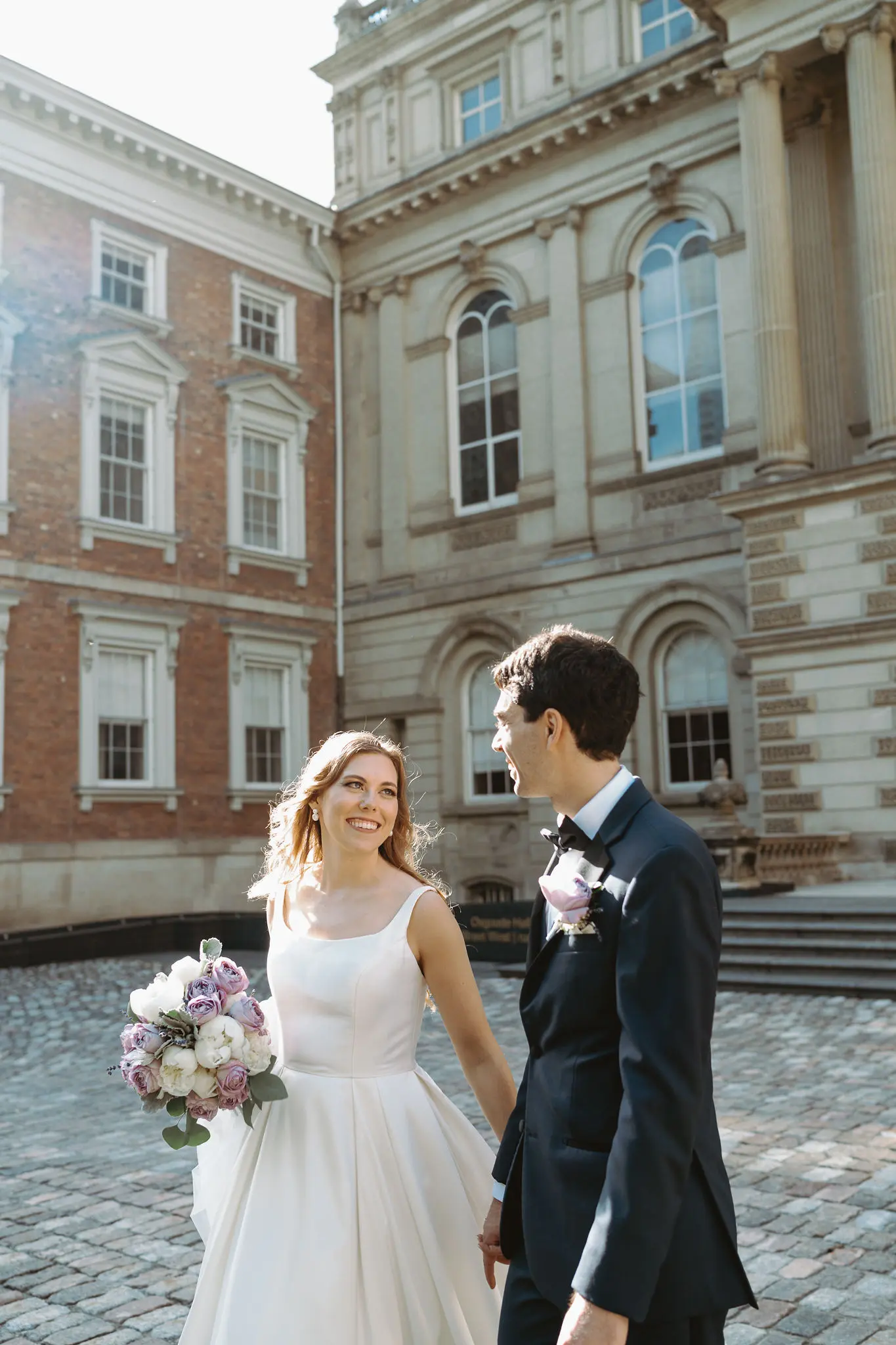 Bride wearing Selena wedding gown by Maggie Sottero walking with her husband