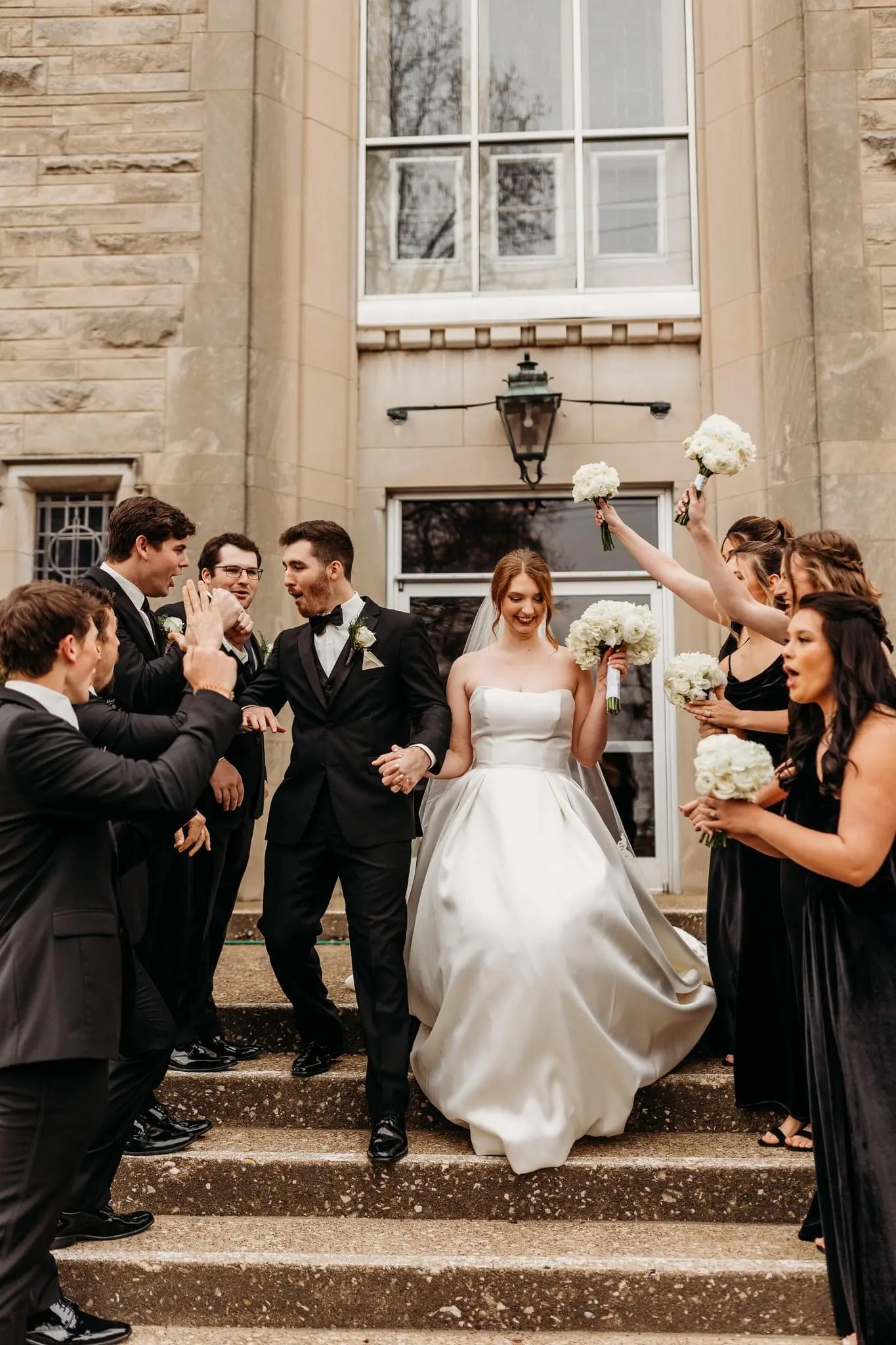 Groom Walking Down Stairs With Bride In a White Wedding Dress Named Selena By Maggie Sottero