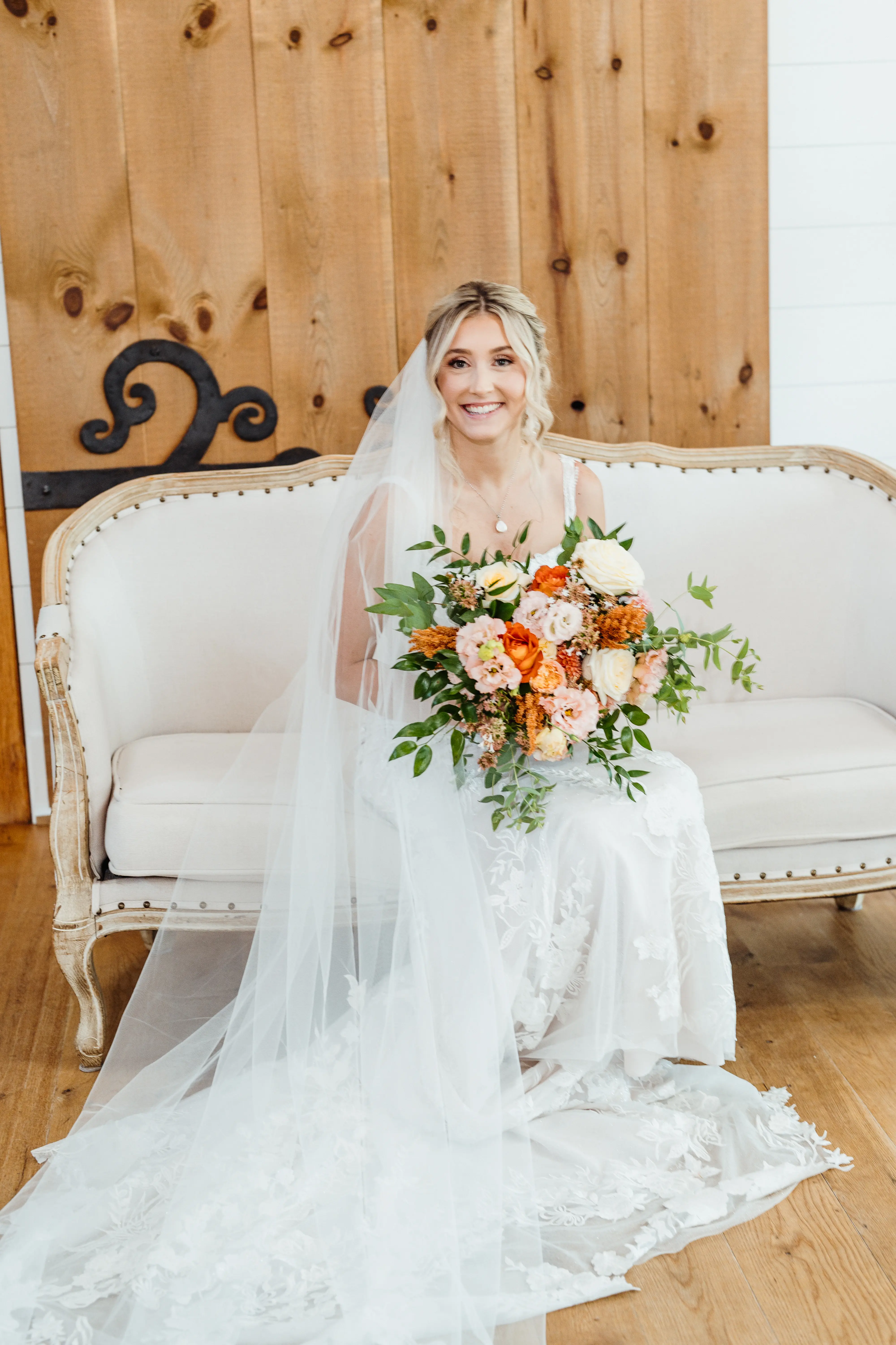Bride wearing Albany wedding dress by Maggie Sottero sitting on a couch