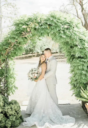 Groom Hugs Bride Wearing Floral Wedding Dress Winter by Maggie Sottero