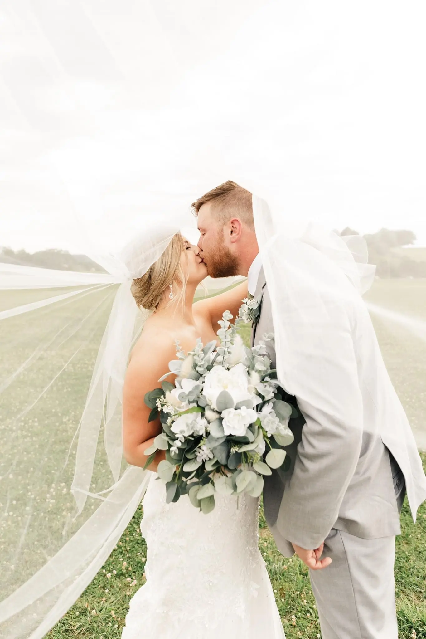 Bride with groom wearing glamorous plus size mermaid wedding dress