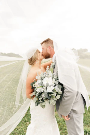 Bride with groom wearing glamorous plus size mermaid wedding dress