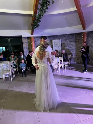 Bride In Long Sleeve Lace Wedding Dress Called Iris By Rebecca Ingram With Groom At Reception