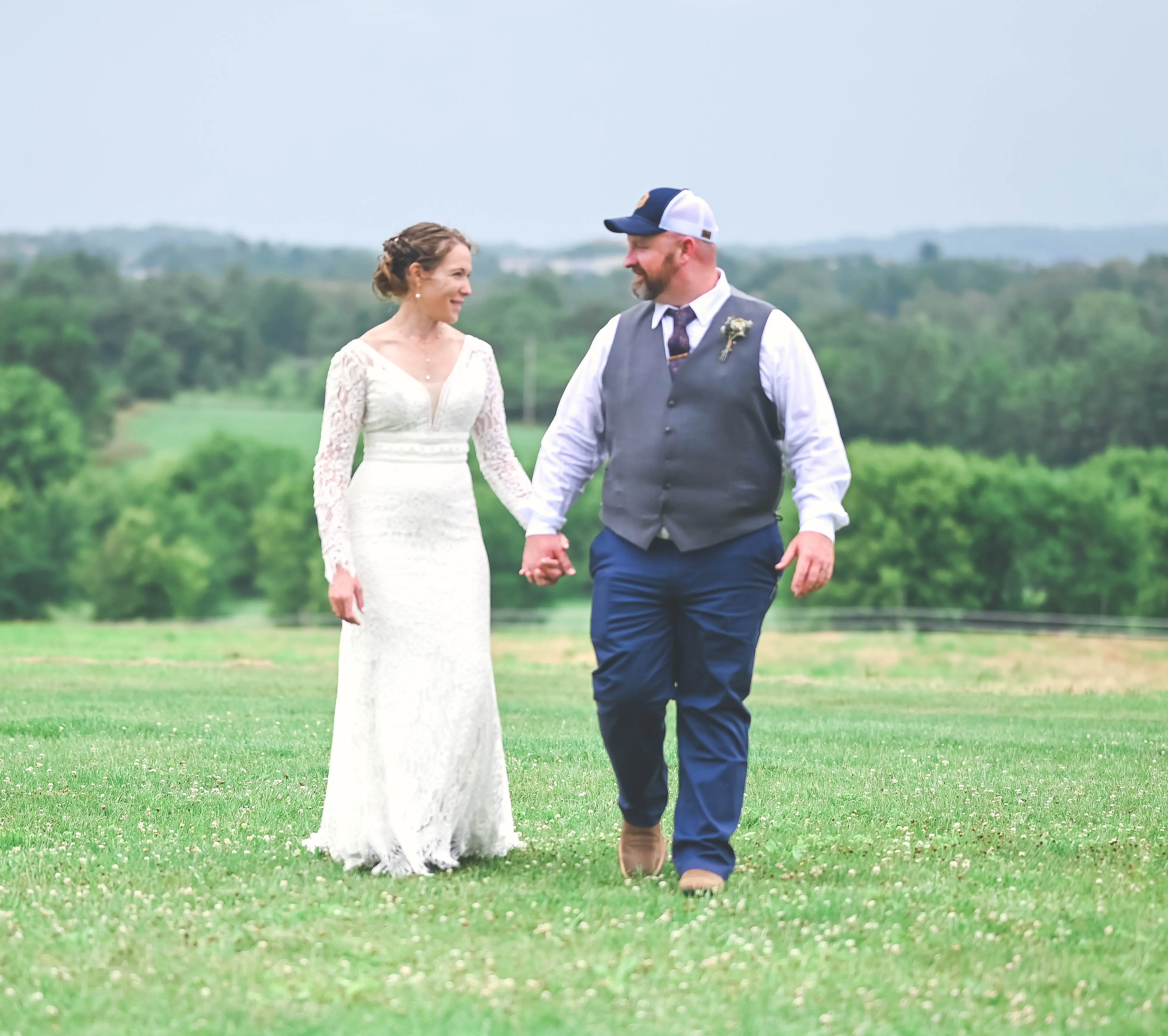 Bride wearing Drita wedding dress by Maggie Sottero holding hands with her husband