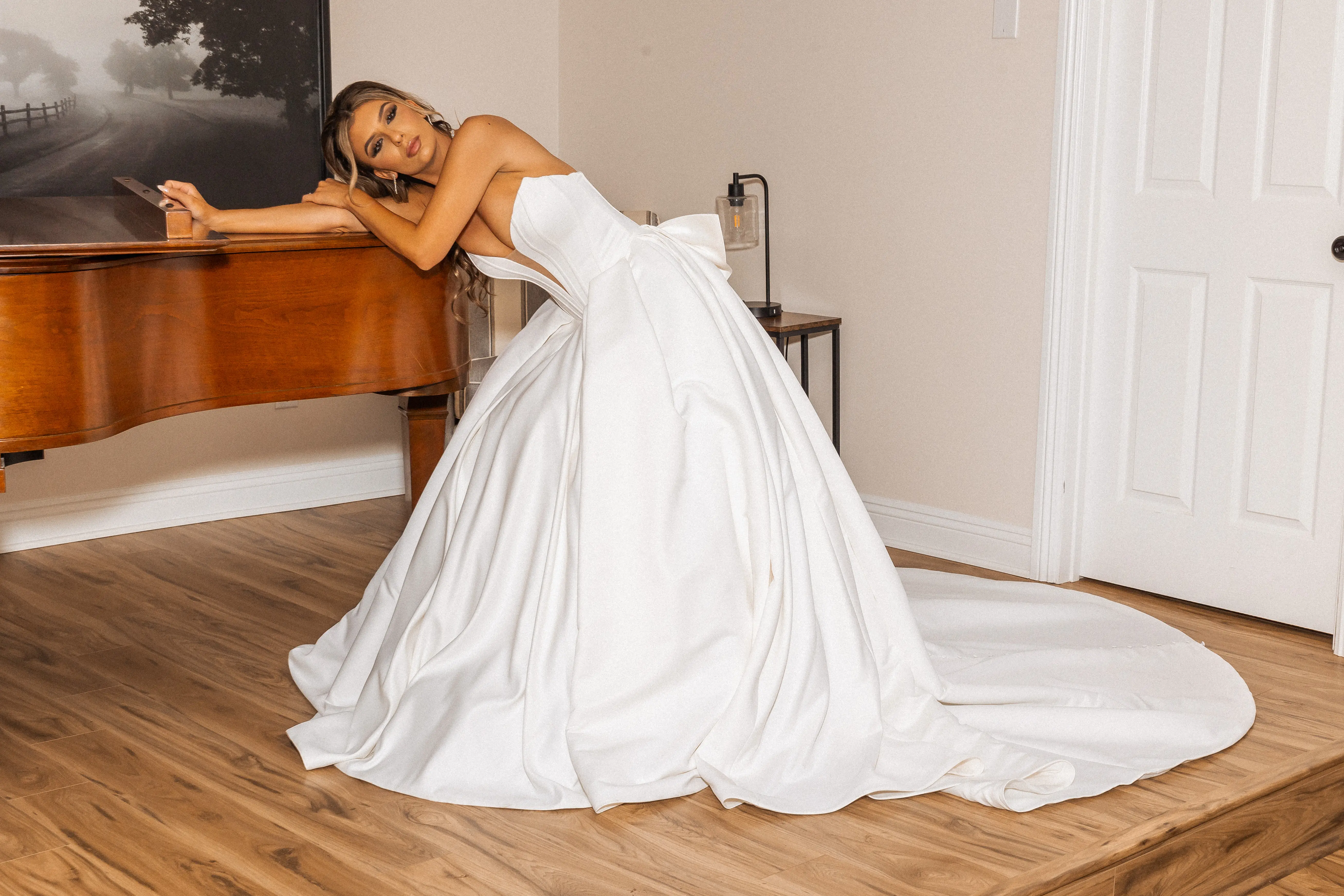 Bride wearing Derrick by Maggie Sottero leaning on a piano