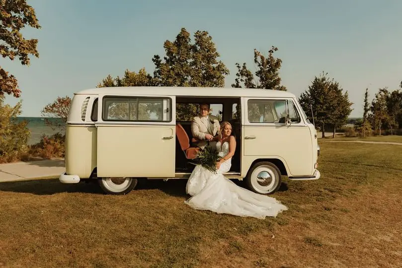 Bride wearing Hattie wedding dress by Rebecca Ingram in a van with her husband