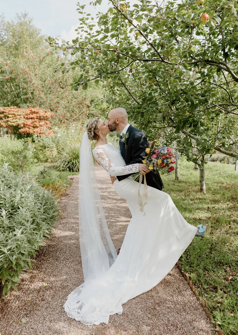 Bride wearing Bethany wedding dress by Rebecca Ingram kissing her husband