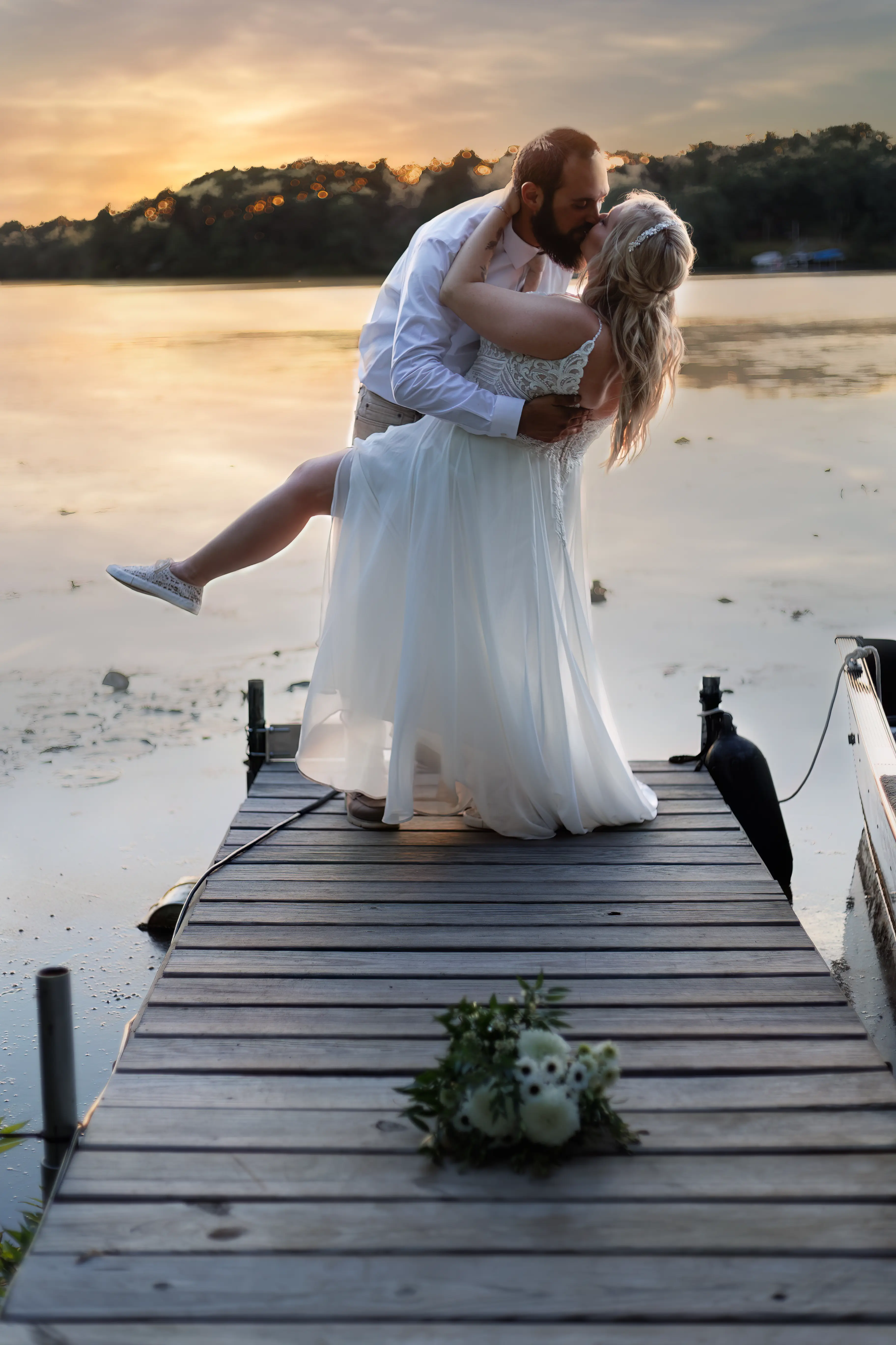 Bride Wearing Beaded Wedding Dress With Flowy Skirt Called Lorraine By Rebecca Ingram Dipped By Groom Kissing