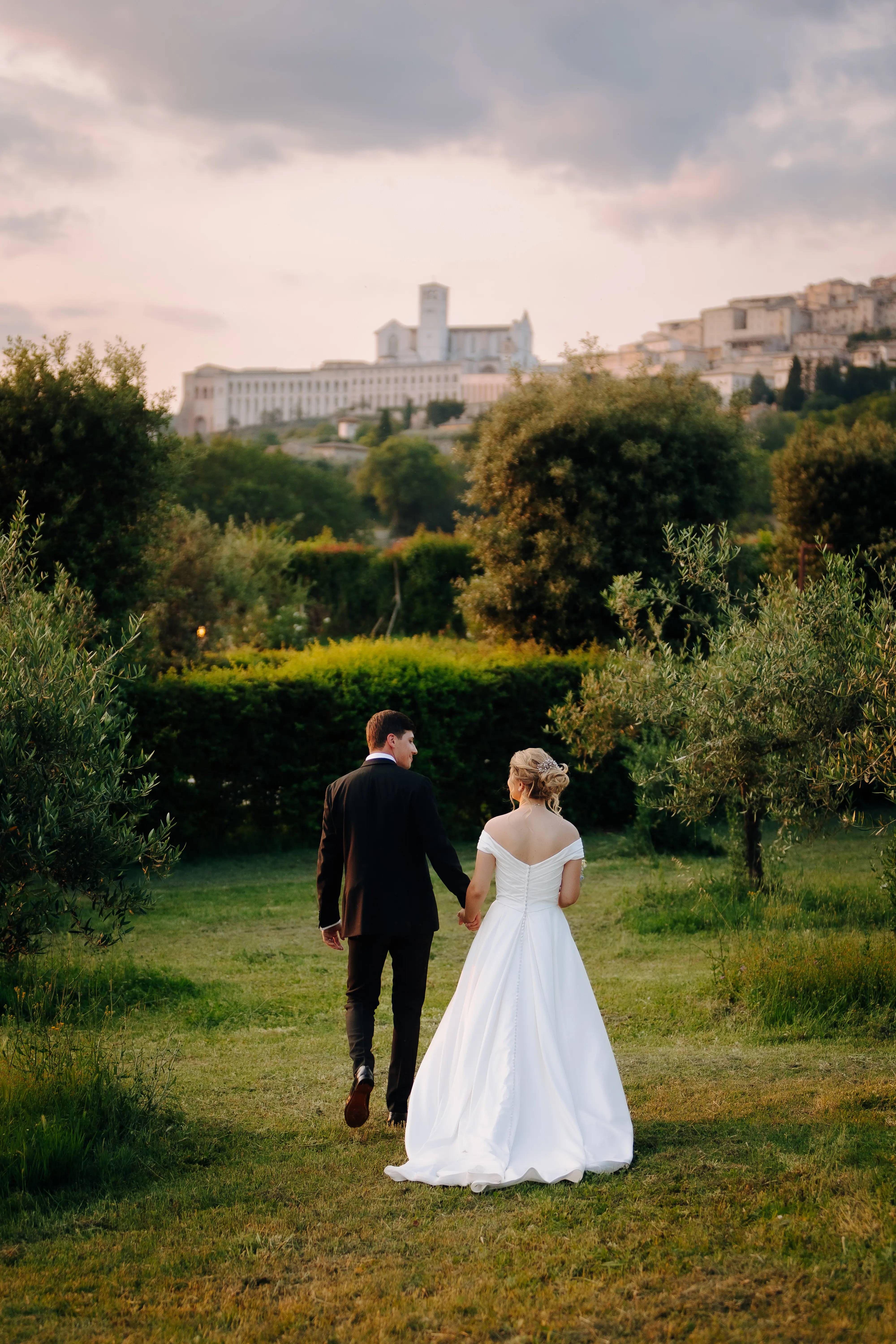 Bride Wearing A-line Classic Wedding Dress Ekaterina By Maggie Sottero Holding Hands And Walking Away With Groom