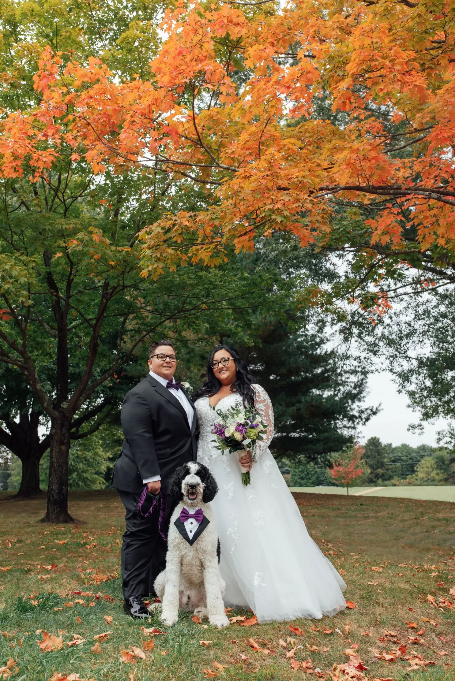 Bride Wearing Vintage Royalty Long Sleeve Wedding Dress Called Raphael By Maggie Sottero Posing With Groom And Fluffy Dog Outside
