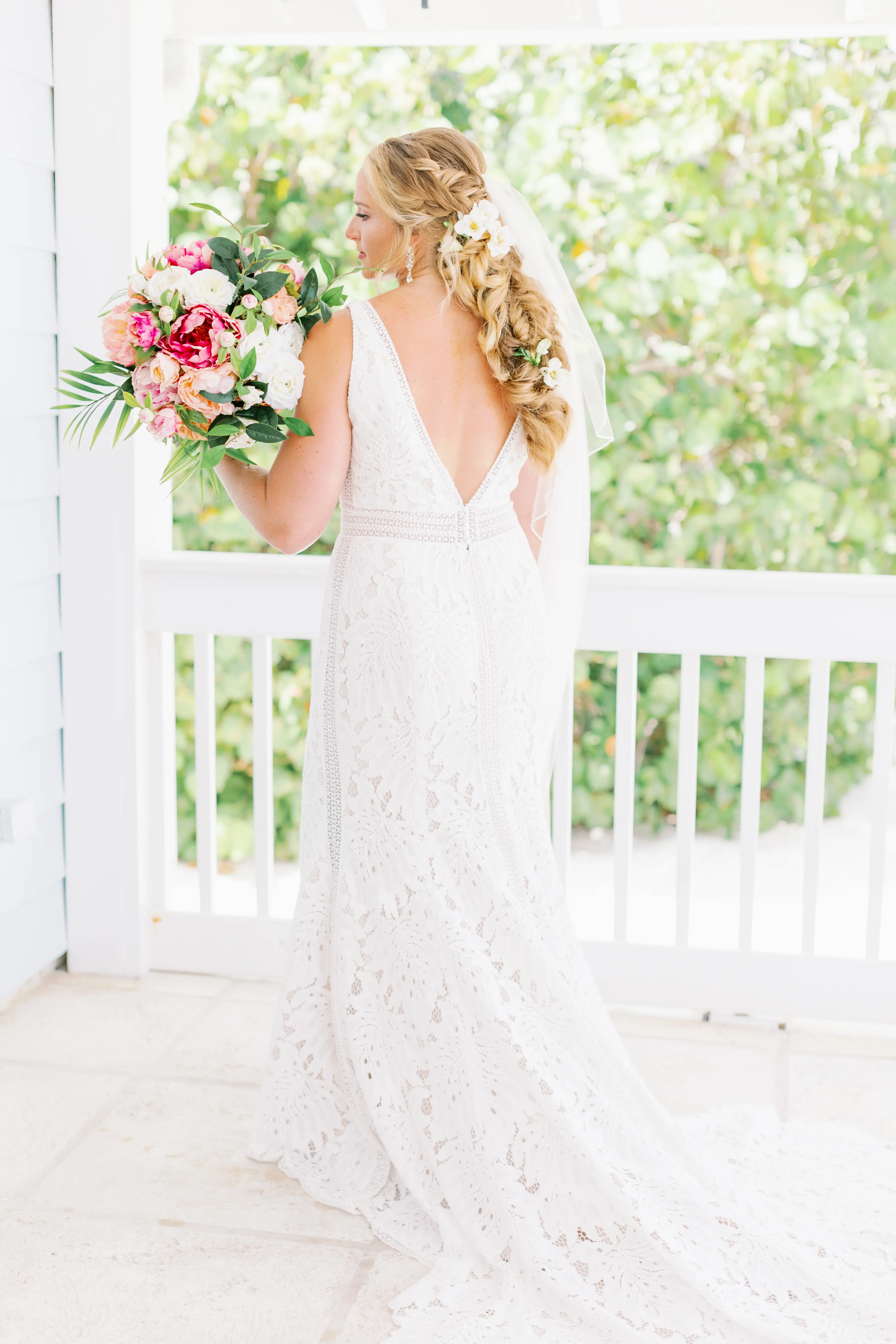 Back view of bride with bright pink bouquet wearing wedding dress called Burke.