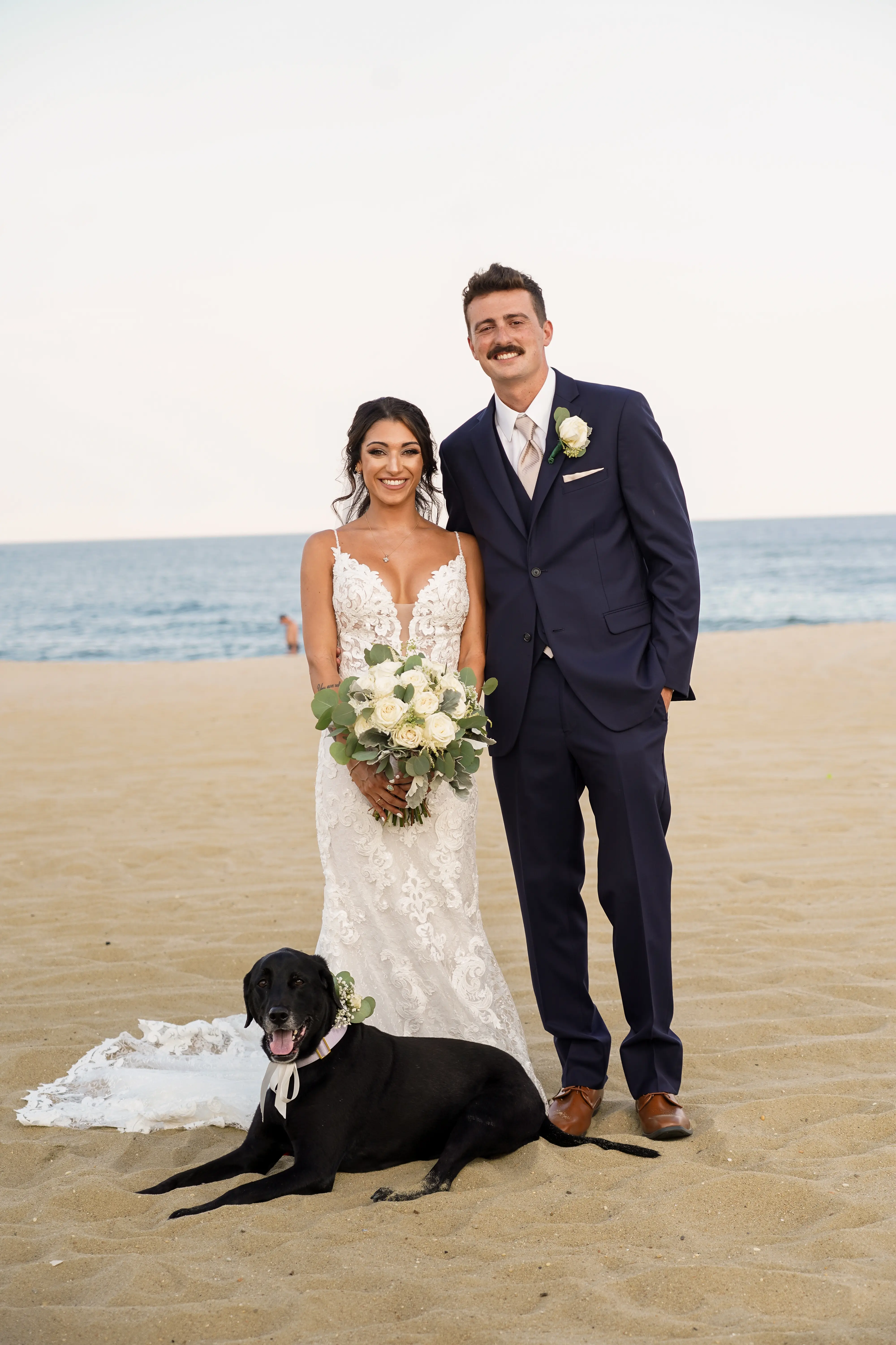 Groom with Dog and Bride at Beach Wedding with Bouquet Wearing Sexy Mermaid Wedding Dress called Tuscany by Maggie Sottero.