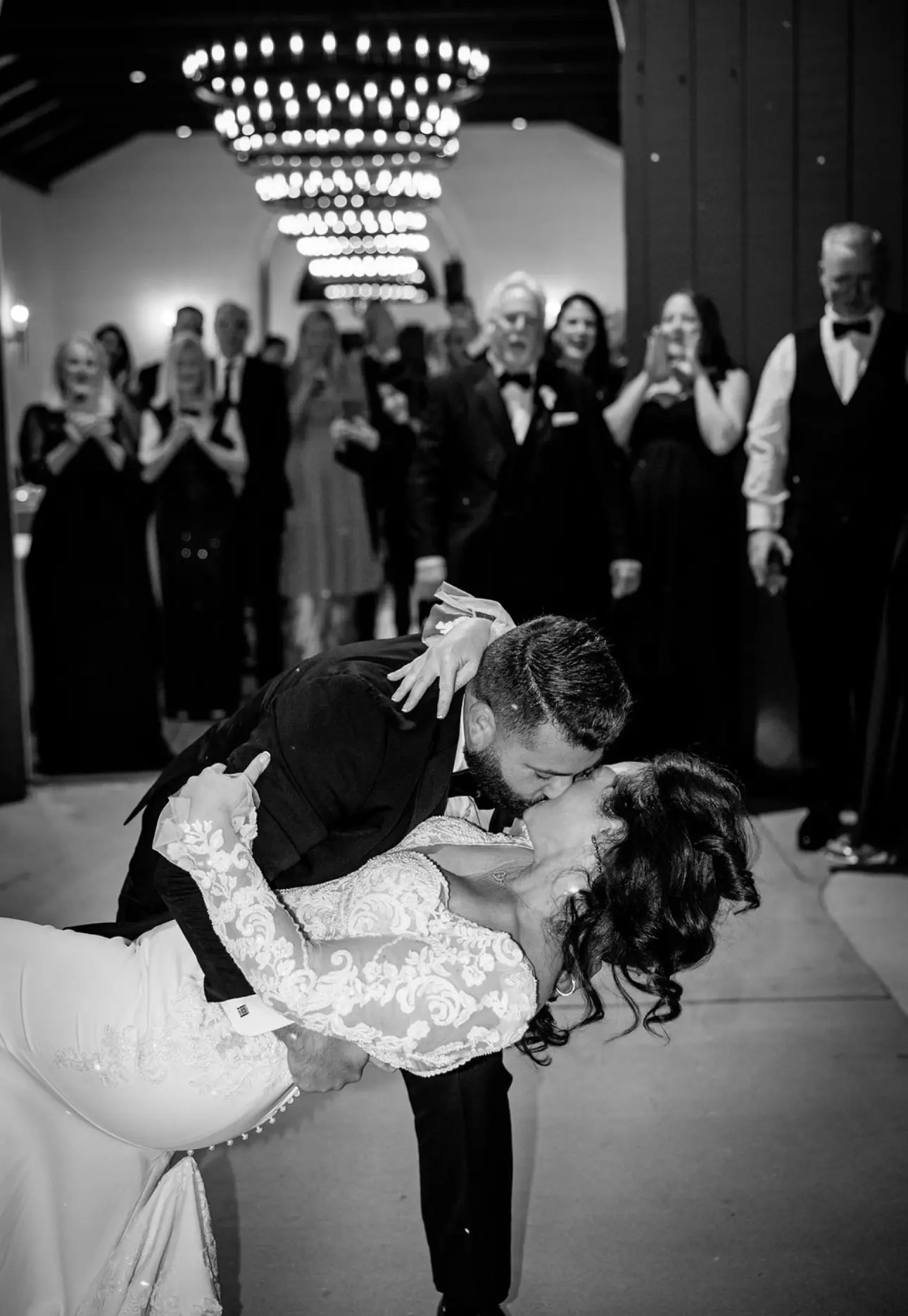 Groom Kissing Bride In A White Long Sleeve Wedding Dress Named Nikki By Maggie Sottero