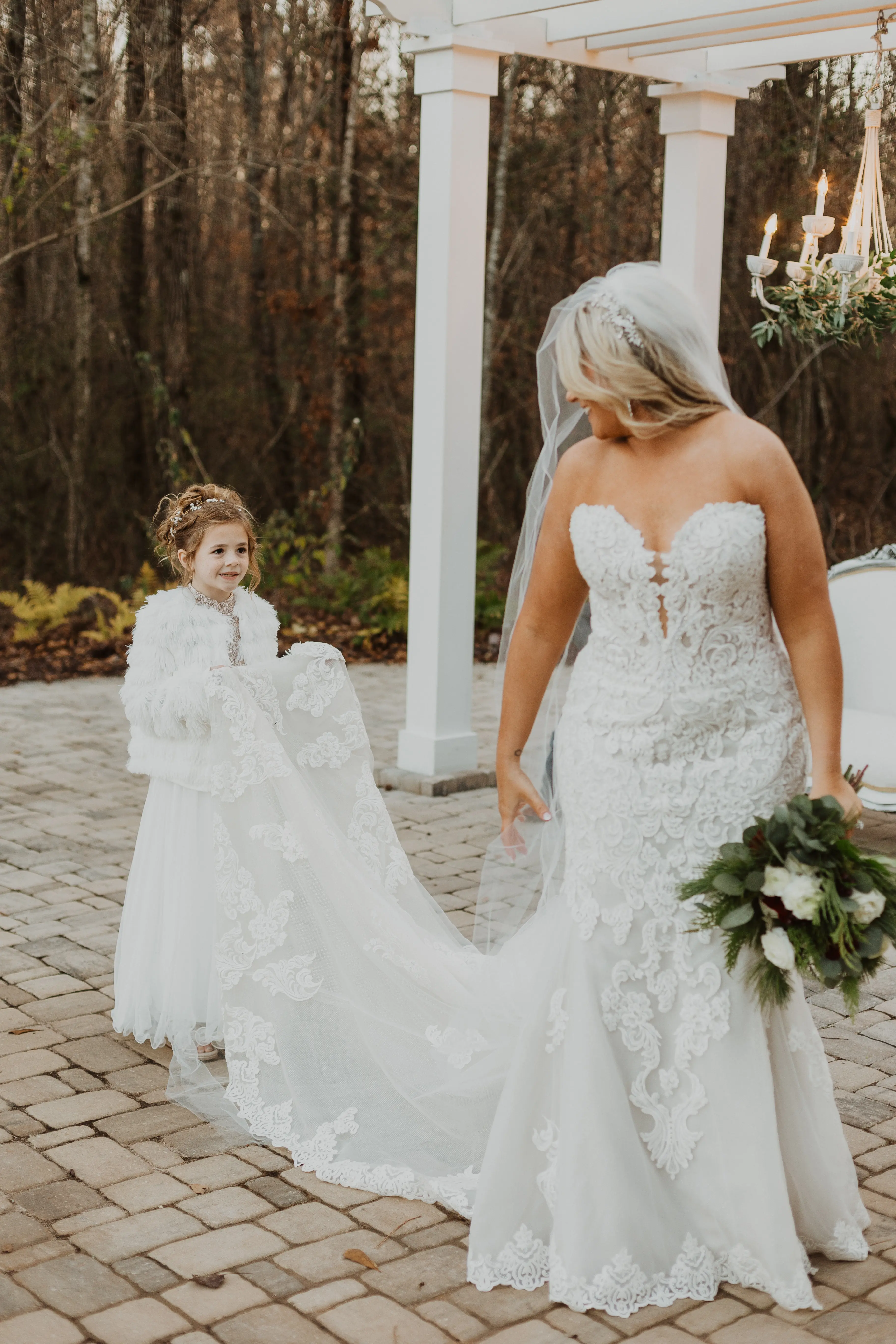 Bride In A Sparkly Lace Fit-And-Flare Wedding Dress Named Fiona By Maggie Sottero With A Flower Girl Holding Her Train