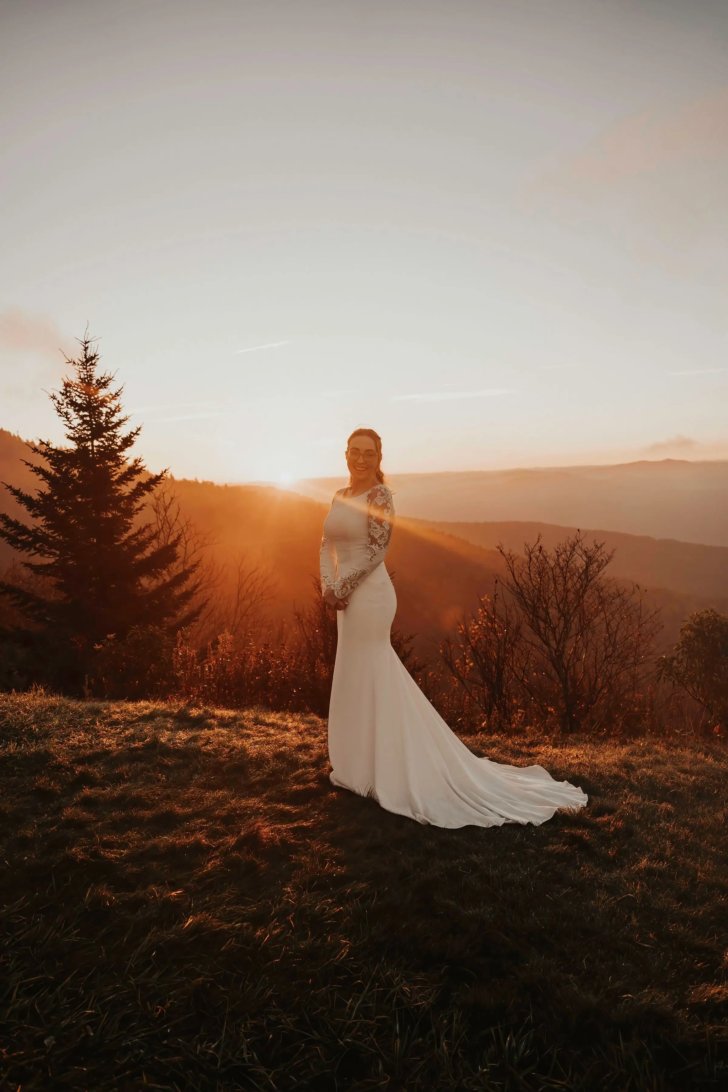 Bride Wearing Simple Long Sleeve Wedding Dress Called Bethany By Rebecca Ingram On A Hill