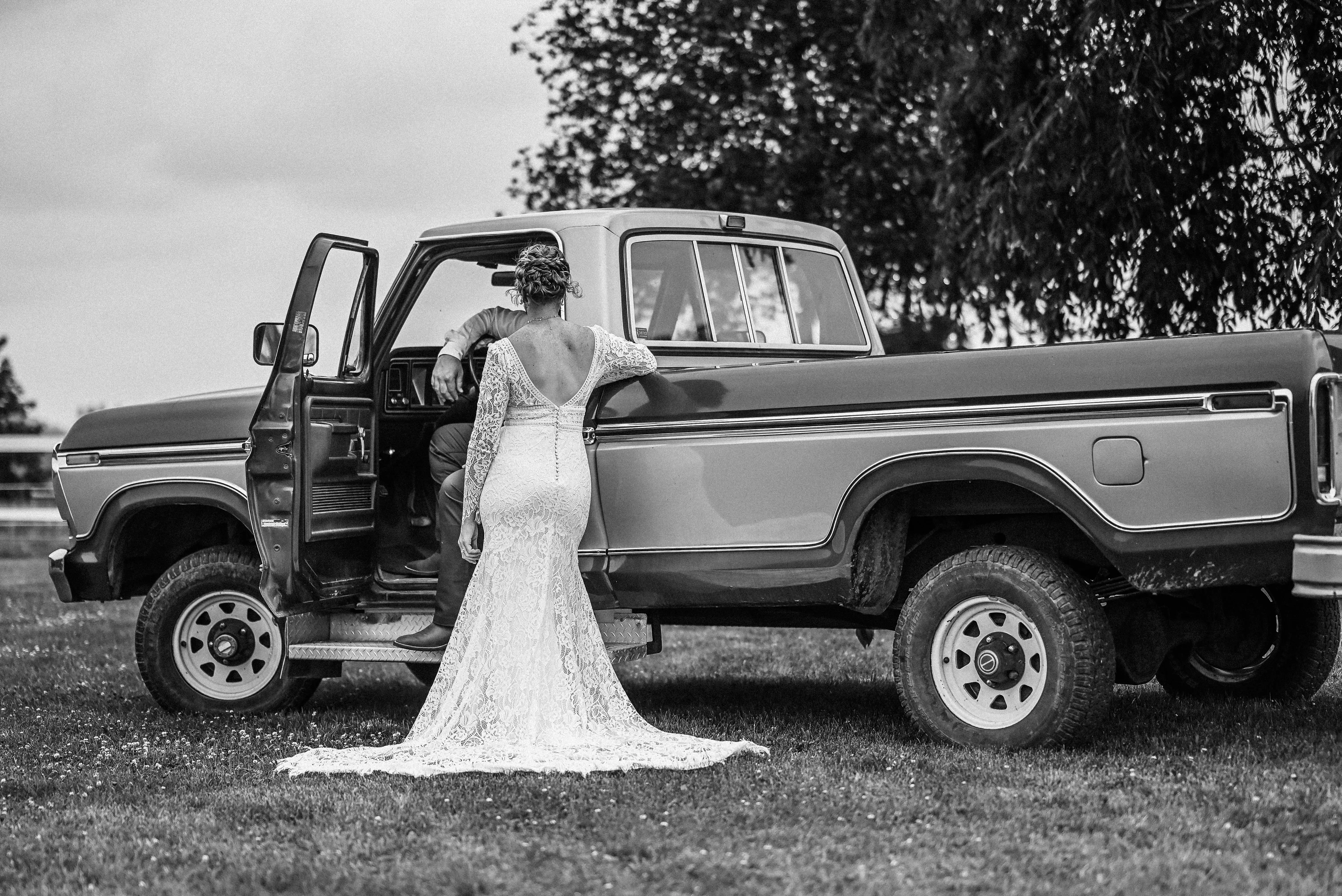 Bride wearing Drita wedding dress by Maggie Sottero in front of a truck