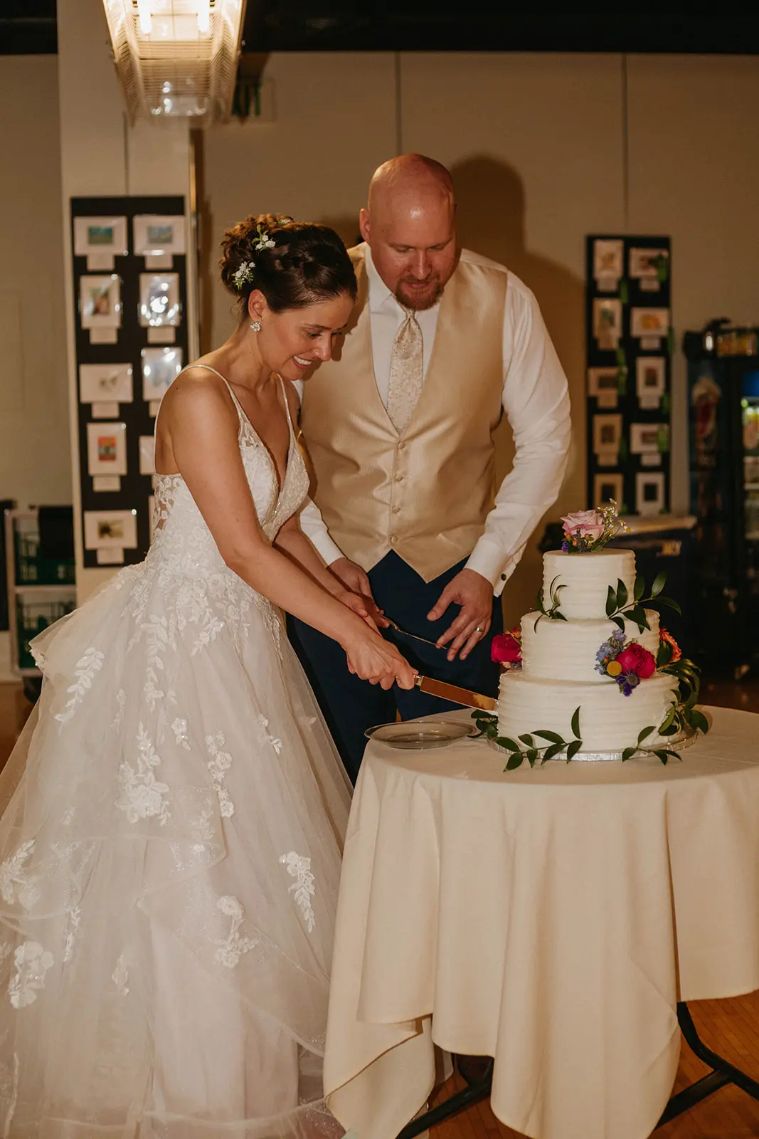 Bride In Floral Lace Bridal Gown Named Lettie By Rebecca Ingram Bride And Groom Cutting Cake