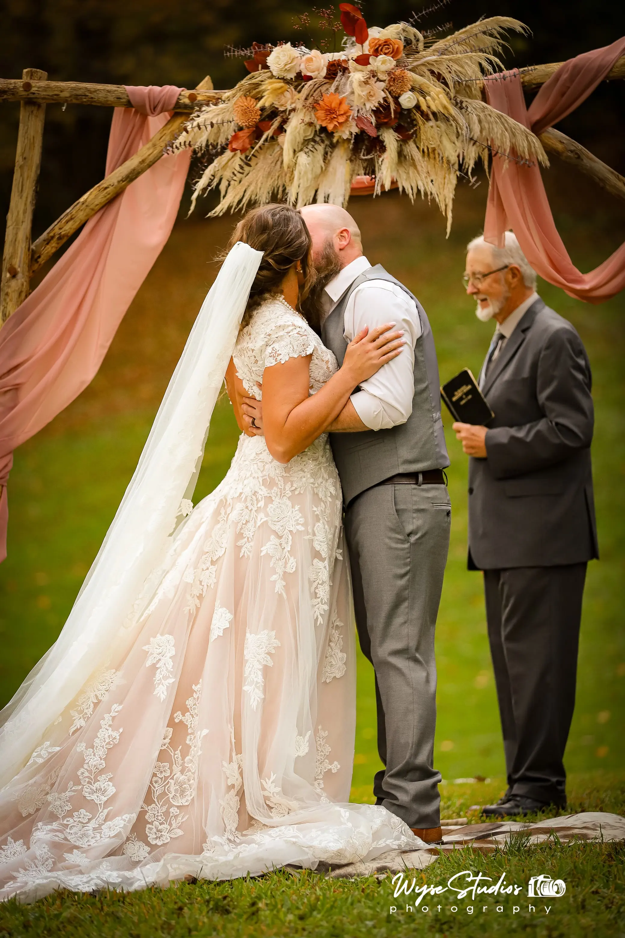 Bride wearing Kingsley wedding gown by Sottero and Midgley kissing her husband during their ceremony