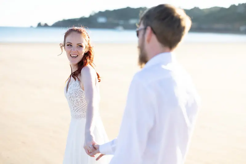 Bride Wearing Affordable Sheath Wedding Dress Called Lorraine By Rebecca Ingram Looking Back At The Groom