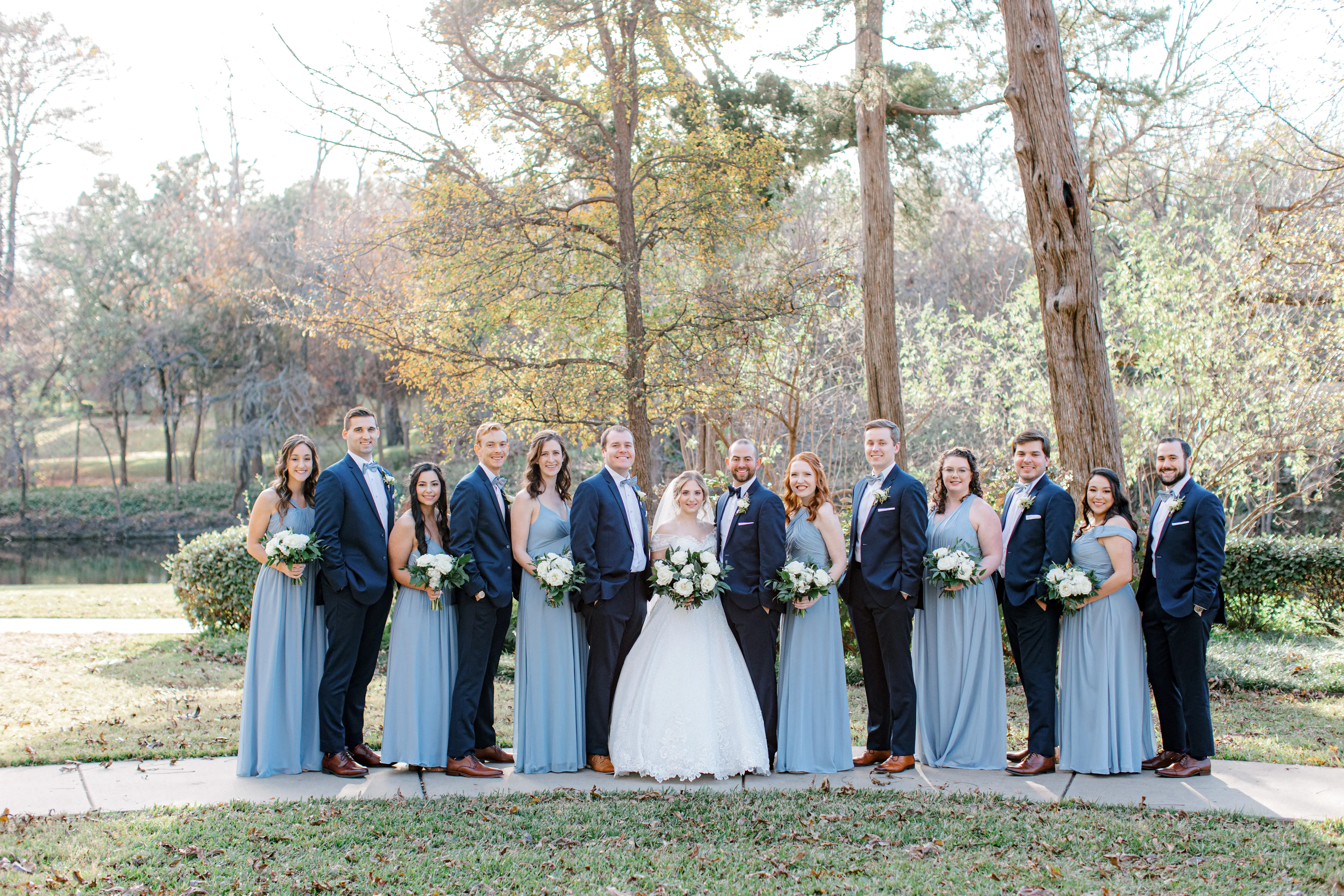 Bridal Party And Groom Posing With Bride Wearing Chic Lace Ball Gown Wedding Dress Called Tristyn By Maggie Sottero