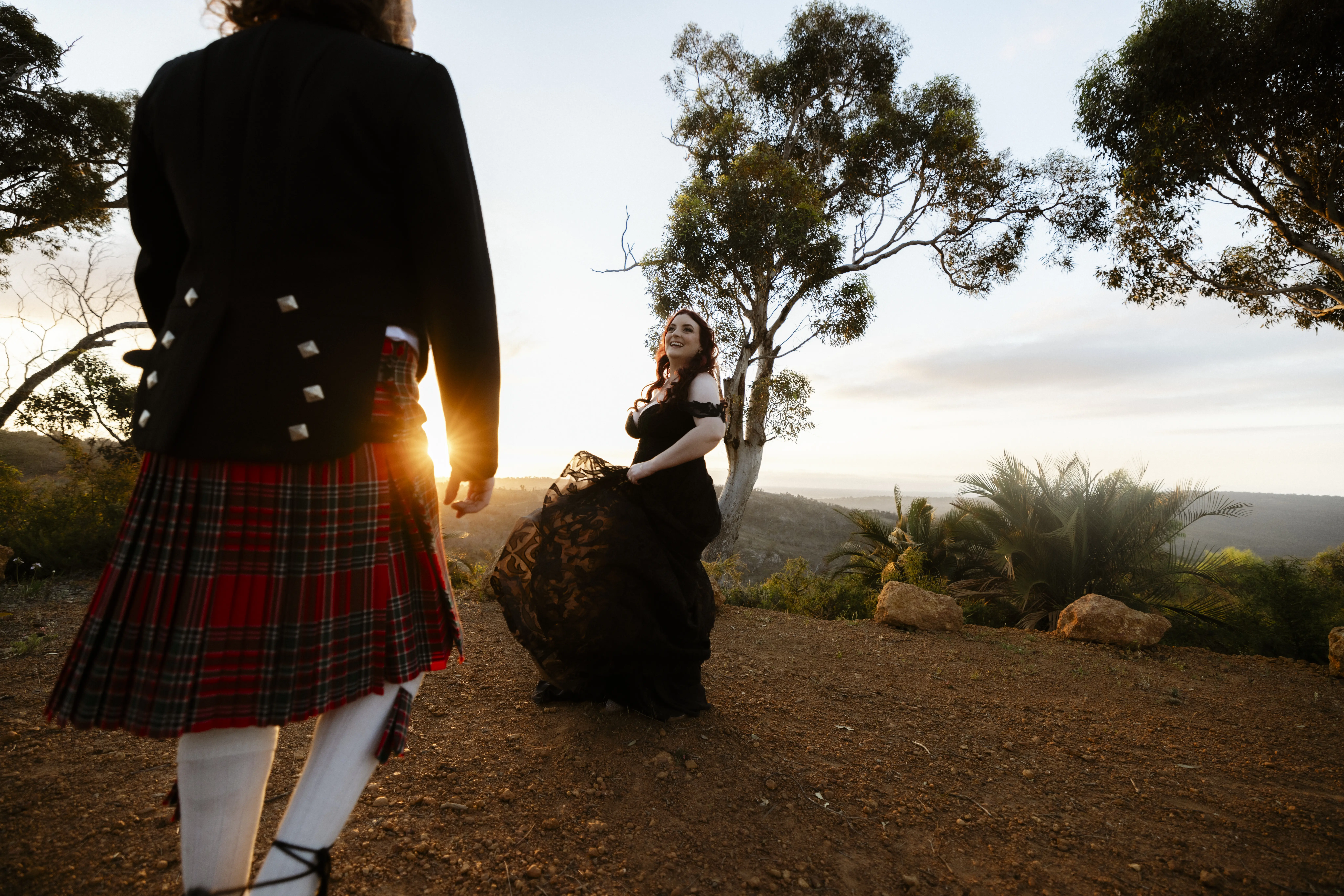 Bride Wearing Black Lace Wedding Dress Called Penny By Maggie Sottero With Sun Filtering Through The Lace And Groom Watching