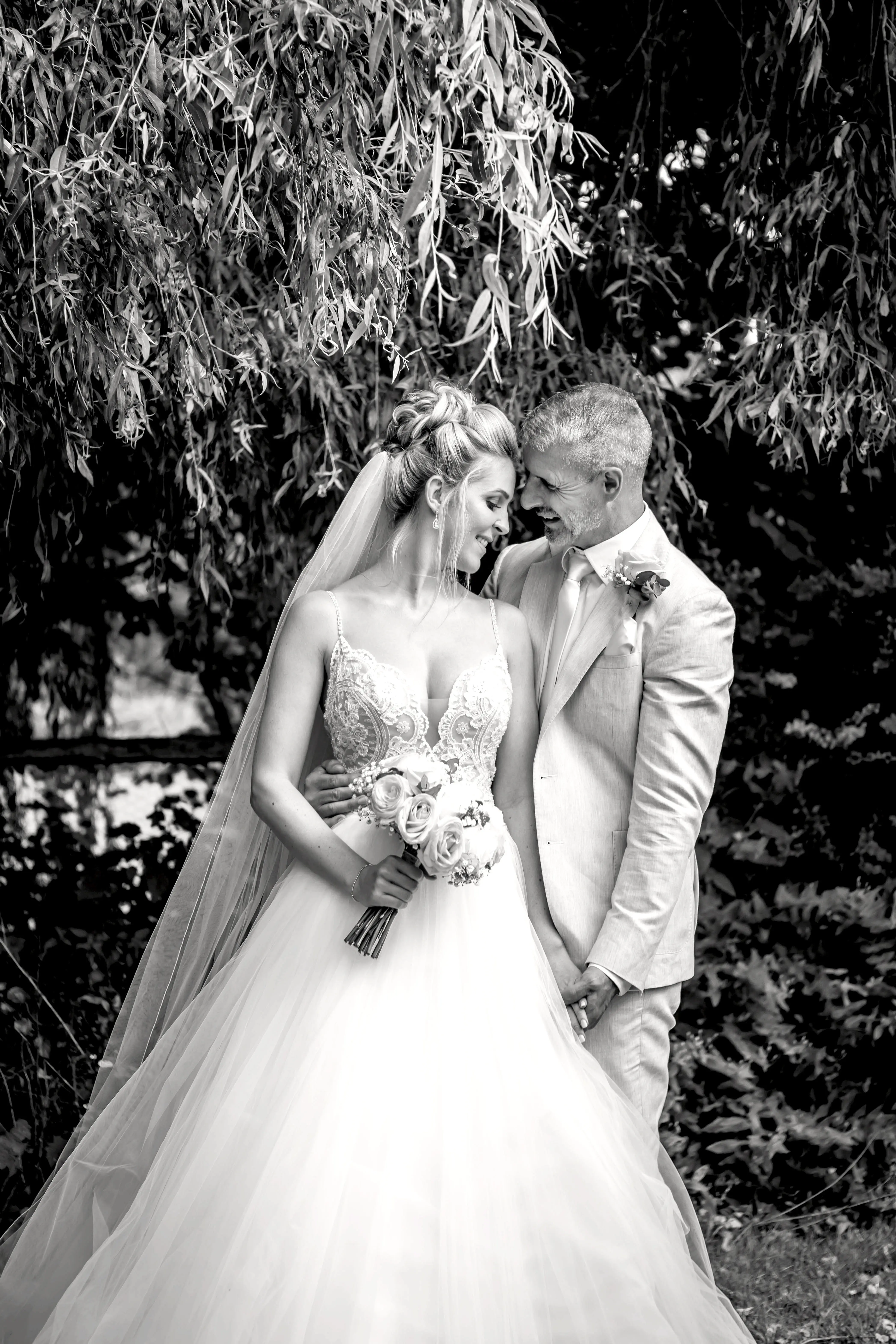 Groom happily looking at his bride wearing Mallory wedding dress by Maggie Sottero.