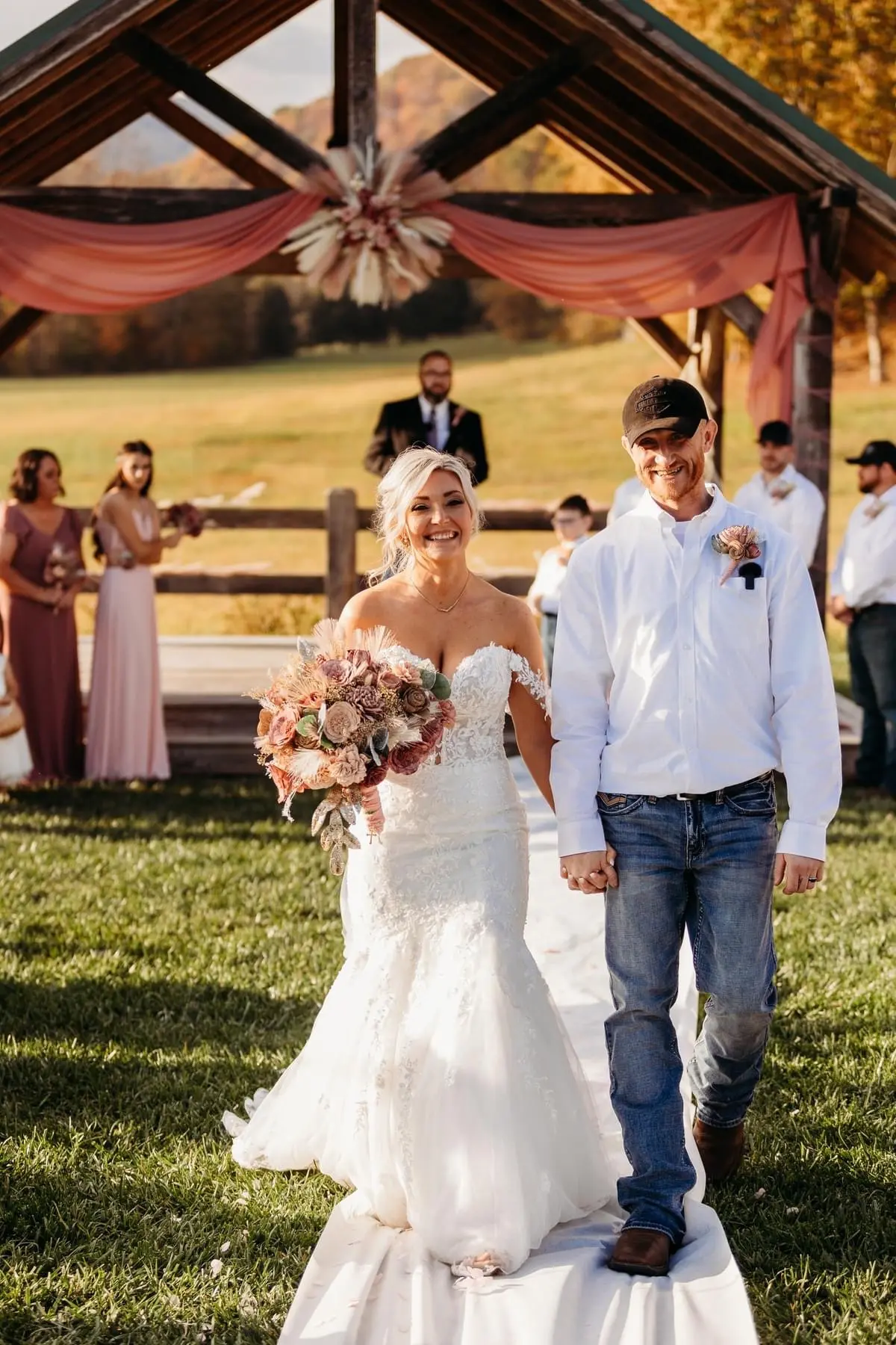 Bride wearing Lennon wedding dress by Maggie Sottero walking down the aisle with her husband