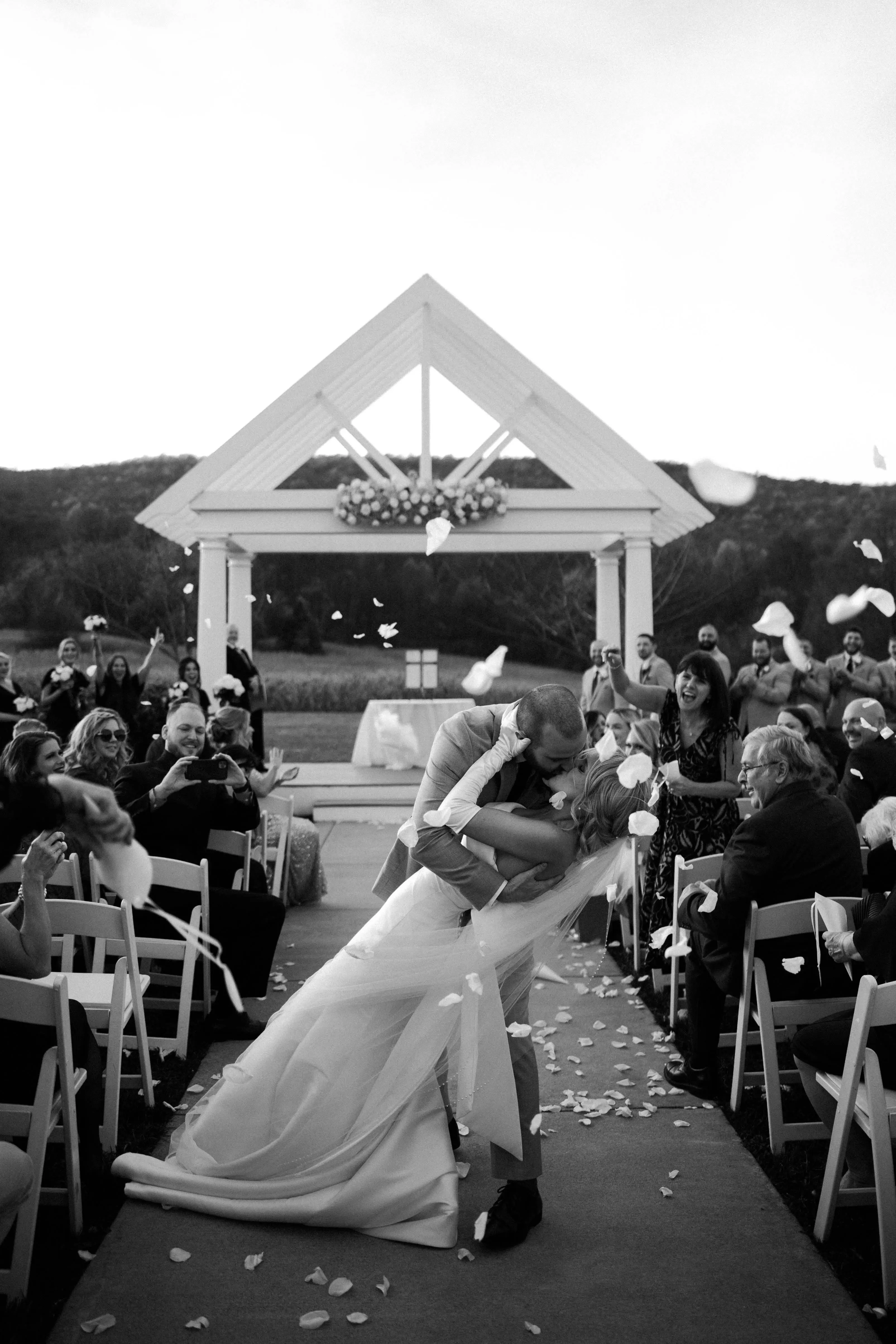 Groom Kissing Bride In A White Strapless Wedding Dress Named Mitchell By Maggie Sottero
